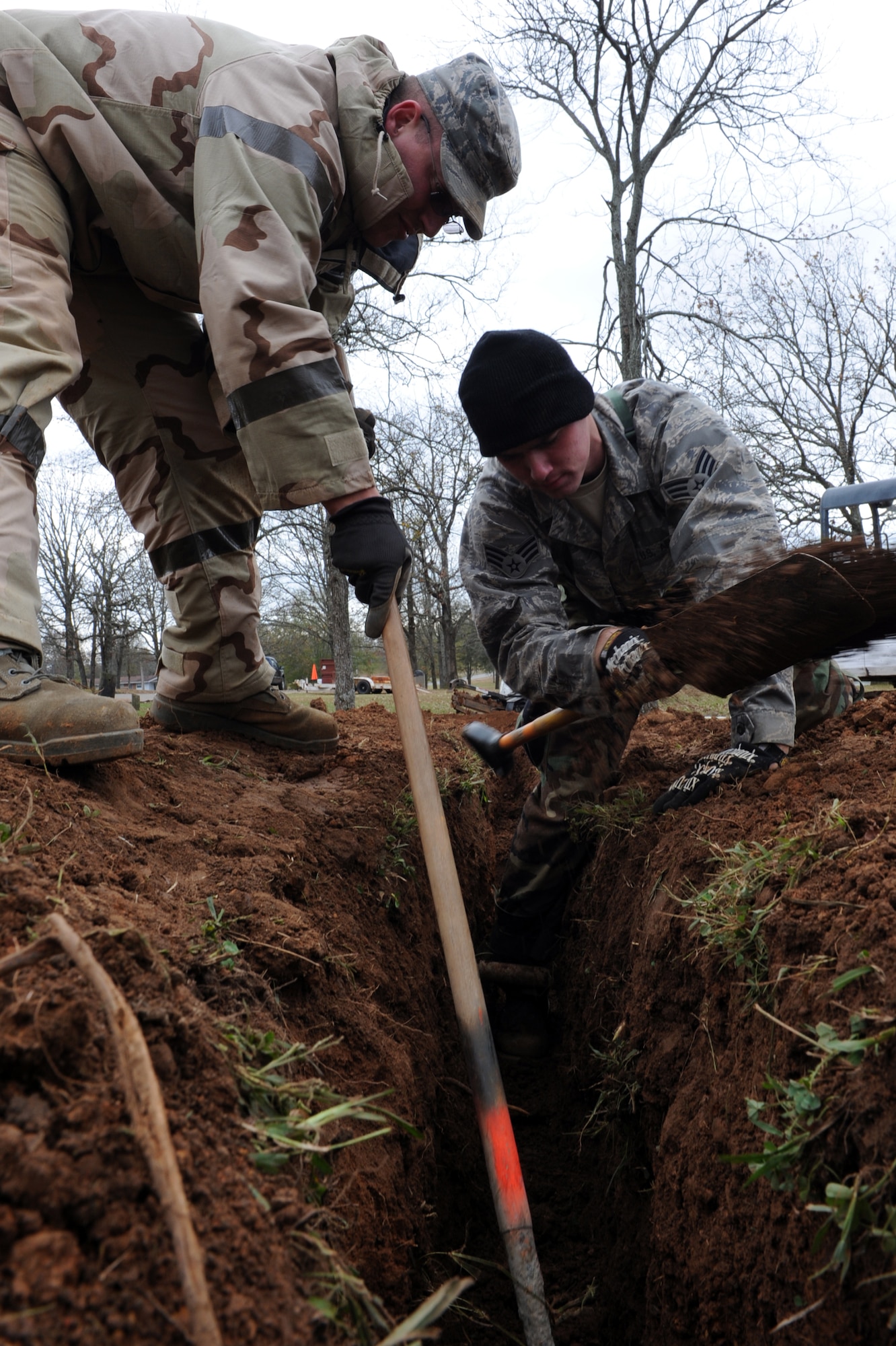 Senior Airman Joseph Rose, 19th Civil Engineer Squadron water, fuels and systems maintenance journeyman; and Senior Airman Donald Goeb, 19th CE heating, ventilation and air conditioning craftsman, work together to clear excess dirt from a trench, connecting a sewage line leading into new restrooms being built at the base lake Nov. 17. (U.S. Air Force photo by Senior Airman Ethan Morgan)