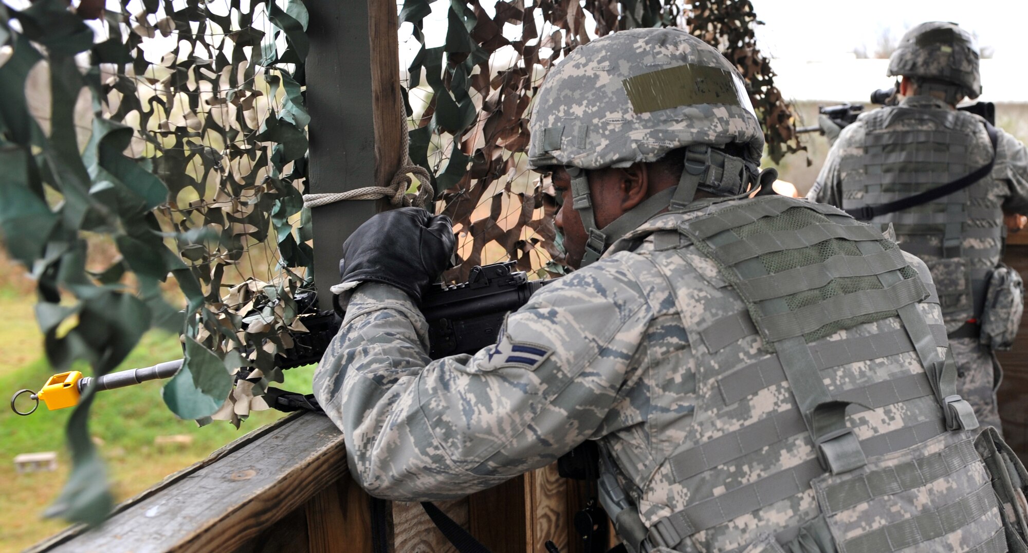 Senior Airman Phillip Fox, 19th Security Forces Squadron pass and registration clerk; and Airman 1st Class Domenique Watkins-Wise, 19th Security Forces Squadron flight line patrolman; scan the perimeter from the watch tower with their M-4 rifles looking for any possible attack during a base exercise Nov. 17. (U.S. Air Force photo by Staff Sgt. Chris Willis)