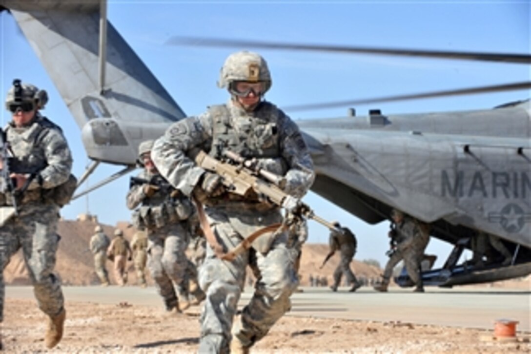 A U.S. Army soldier of the 2nd Battalion, 504th Parachute Infantry Regiment, 1st Brigade Combat Team, 82nd Airborne Division runs over to provide security after unloading from a CH-53 Sea Stallion helicopter during a static loading exercise at Camp Ramadi, Iraq, on Nov. 15, 2009.  U.S. soldiers and Marines and Iraqi soldiers are training together, loading and unloading on a Sea Stallion to prepare for upcoming missions.  
