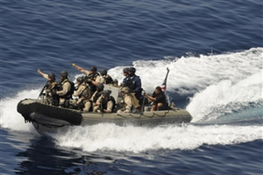 A U.S. Navy visit, board, search and seizure team from the guided-missile cruiser USS Chosin (CG 65) point to a suspected pirate dhow as they make their approach to board it during counter-piracy operations in the Gulf of Aden on Nov. 12, 2009.  The Chosin is the flagship for Combined Joint Task Force 151, a multinational task force established to conduct counter-piracy operations off the coast of Somalia.  