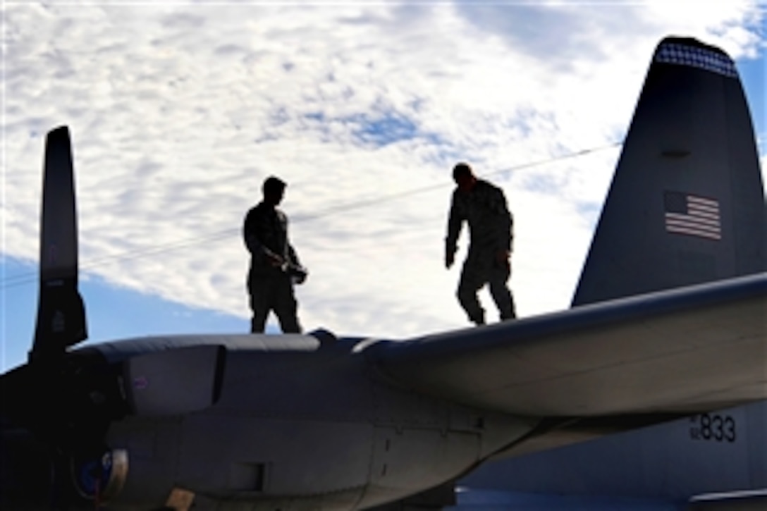 Two U.S. Air Force C-130 Hercules crew chiefs conduct a post-flight inspection of their aircraft at Nellis Air Force Base, Nev., Nov. 18, 2009. The crew and aircraft participated in the biannual, U.S. Air Force Weapons School exercise, which provides realistic training for combat Air Force, mobility Air Force and U.S. Army personnel. About 40 C-17 and C-130 aircraft from Air Force bases around the world flew about 400 soldiers from Fort Bragg, N.C.