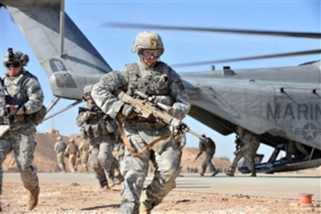 A U.S. Army soldier of the 2nd Battalion, 504th Parachute Infantry Regiment, 1st Brigade Combat Team, 82nd Airborne Division runs over to provide security after unloading from a CH-53 Sea Stallion helicopter during a static loading exercise at Camp Ramadi, Iraq, on Nov. 15, 2009.  U.S. soldiers and Marines and Iraqi soldiers are training together, loading and unloading on a Sea Stallion to prepare for upcoming missions.  
