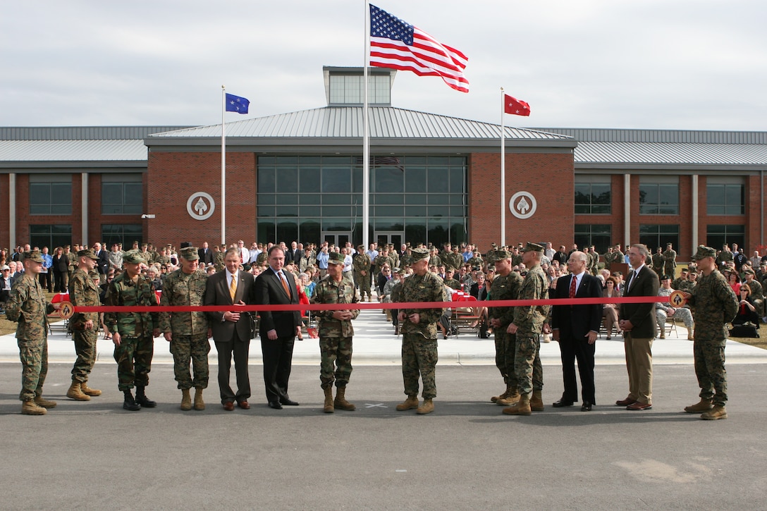 Gen. James Amos, assistant commandant of the Marine Corps, (center right) and Adm. Eric T. Olson, commander of U.S. Special Operations Command, (center left) prepare to cut a ribbon during ceremony meant to commemorate the new U.S. Marine Corps Forces, Special Operations Command Headquarters building Nov. 20, on Stone Bay here. The facility cost more than $51 million to create and was part of a $259 million project.