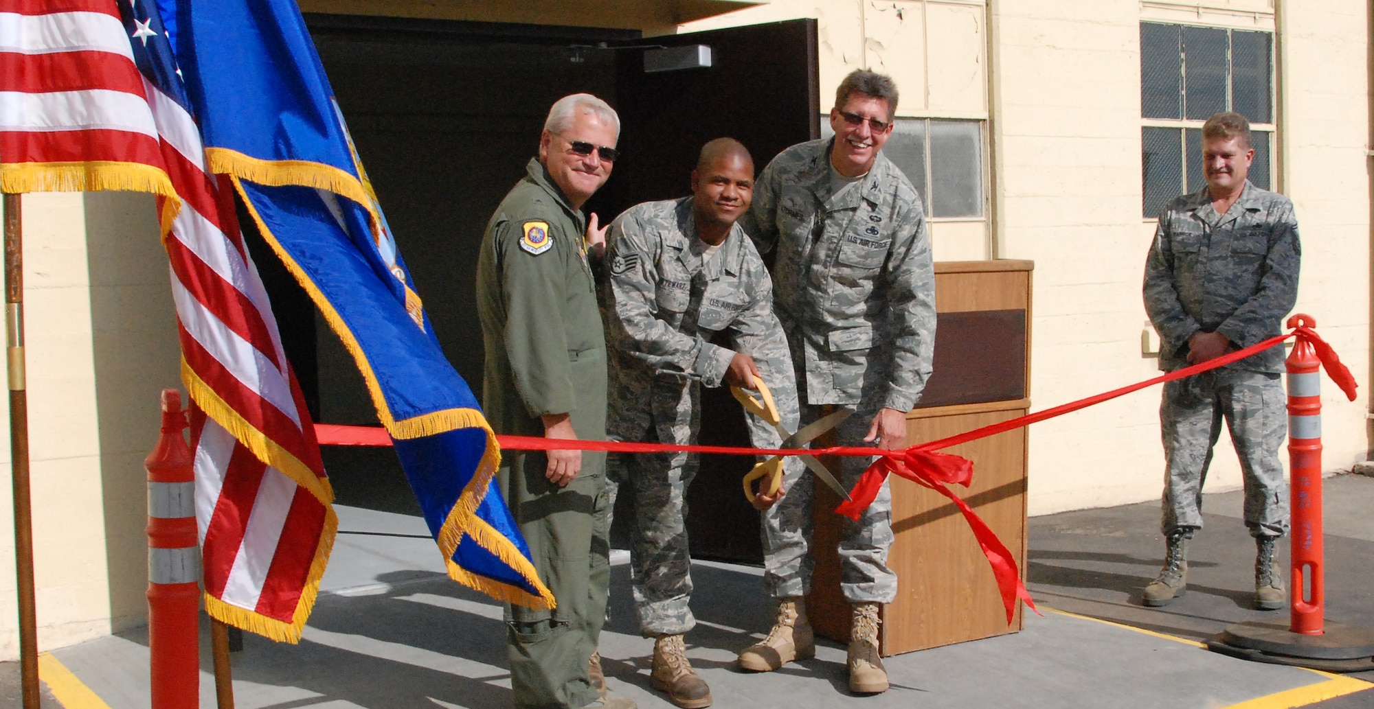 452nd Air Mobility Wing Commander Brig. Gen. James Melin, Staff Sgt. Aaron Stewart and Maintenance Group Commander Col. Robert Stormes cut the ribbon on the new 752nd Aircraft Maintenance Squadron building.  (U.S. Air Force photo by Megan Just)