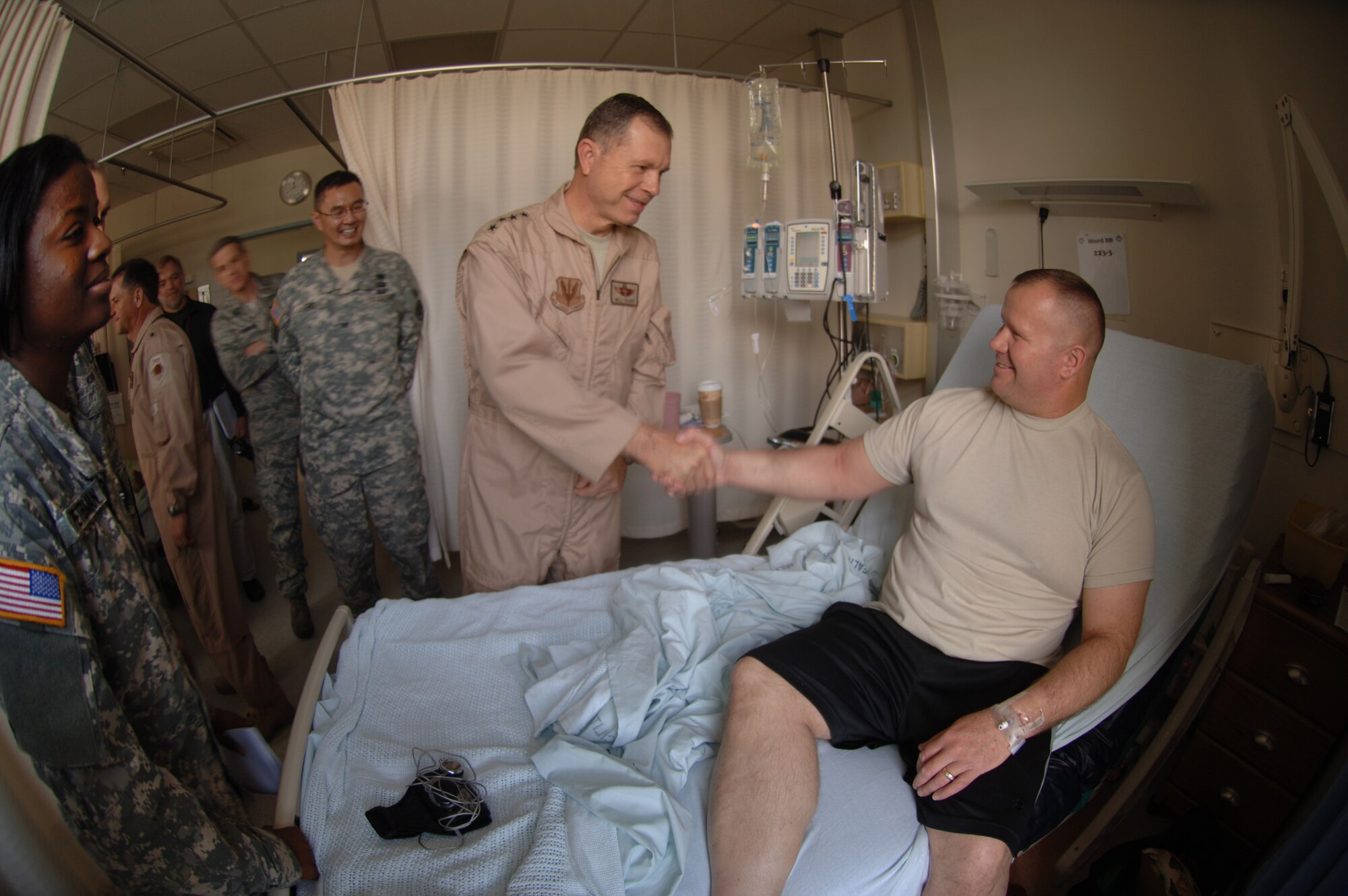 Commander of Air Combat Command, Gen. William M. Fraser III,  visits Landstuhl Regional Medical Center, Nov. 20, where he met U.S. Army Staff Sgt. Brian Bunch of the 546 Maintenance Battalion, who, following treatment for injuries sustained in Afghanistan, was about to be discharged to return to his home station of Fort. Polk, La. Hospital commander, U.S. Army Col. John Cho (third from right), and charge nurse, U.S. Army Capt. Ebony Peterman (left) helped guide the hospital tour. Since 2004, the hospital has treated more than 58,000 wounded U.S. and coalition servicemembers and civilians injured in Iraq and Afghanistan. (Photo: Master Sgt. Scott Wagers/Defense Media Activity Ramstein)