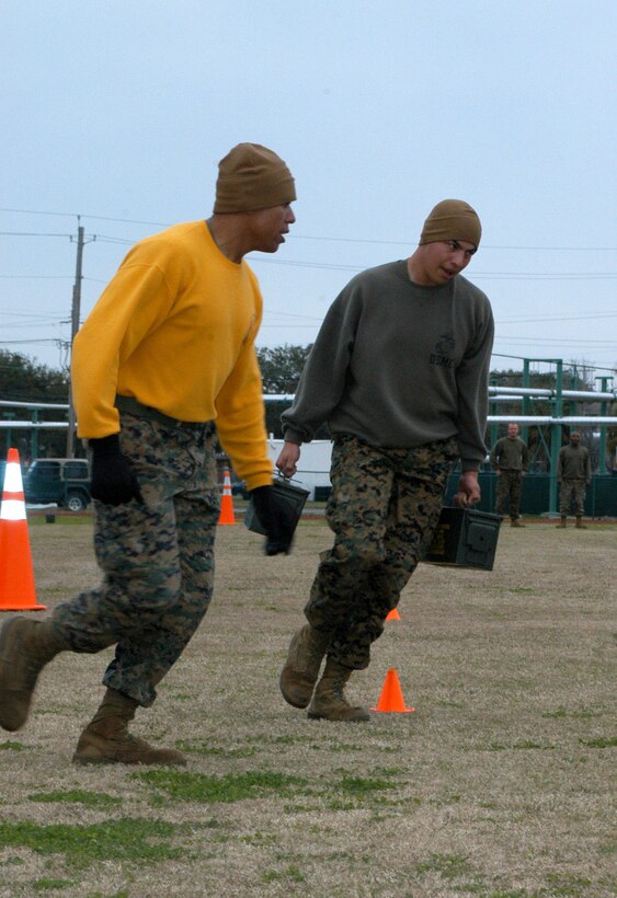 Curtis Rankin, the S-4 chief for Headquarters Company at 2nd Recruit Training Battalion, runs with Sgt. Andrew Chavez, a contracting specialist. Chavez is carrying two 30-pound ammunition cans during the 40-yard run portion of the Combat Fitness Test trial.