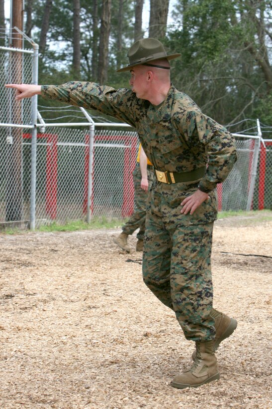 Staff Sgt. Gerald Kirby, 28, from Ridge Manor, Fla., and a drill instructor for Hotel Company, 2nd Recruit Training Battalion, instructs recruits at the Rappel Tower Monday.::n::