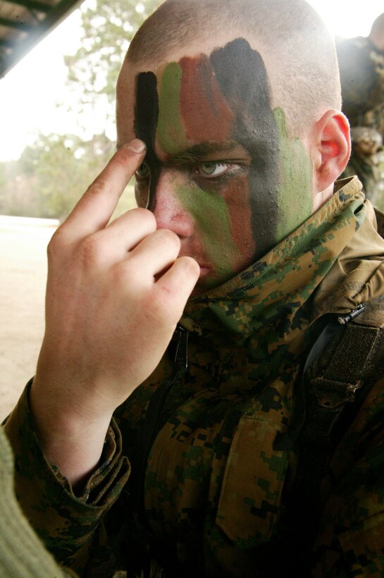 Pvt. Michael Downer, a recently-graduated Marine from 2nd Recruit Training Battalion's Echo Company, covers his face with cammie paint to help conceal himself during the Crucible Jan. 18. Cammie paint is used by Marines around the world to help them stay concealed during missions.