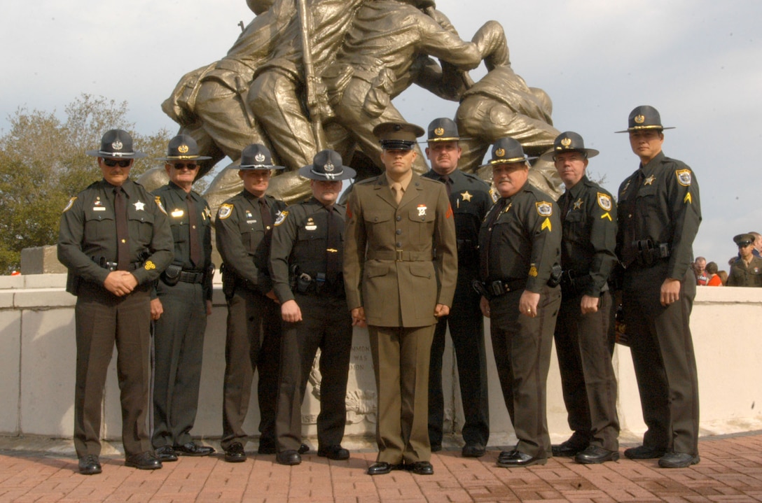 Pfc. Brett Lockhart, a new Marine and former police officer, stands with his former co-workers from the Brevard County Sheriff's Office, in Titusville, Fla. Lockhart joined not because of a family tradition, but because of a brotherhood tradition.