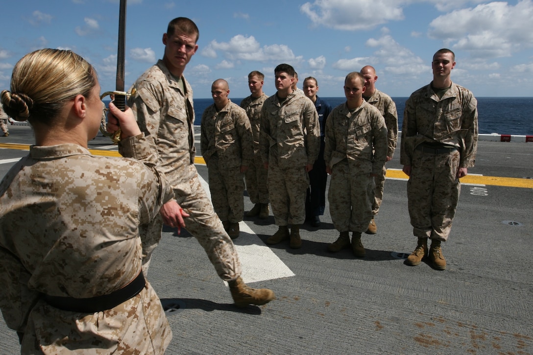 Sgt. Michael Adams evaluates Cpl. Erin Kailing as she performs drill and sword manual on the flight deck of USS Bonhomme Richard Nov. 21. Kailing and other corporals with the 11th Marine Expeditionary Unit performed their final drill portion of a corporal's course.