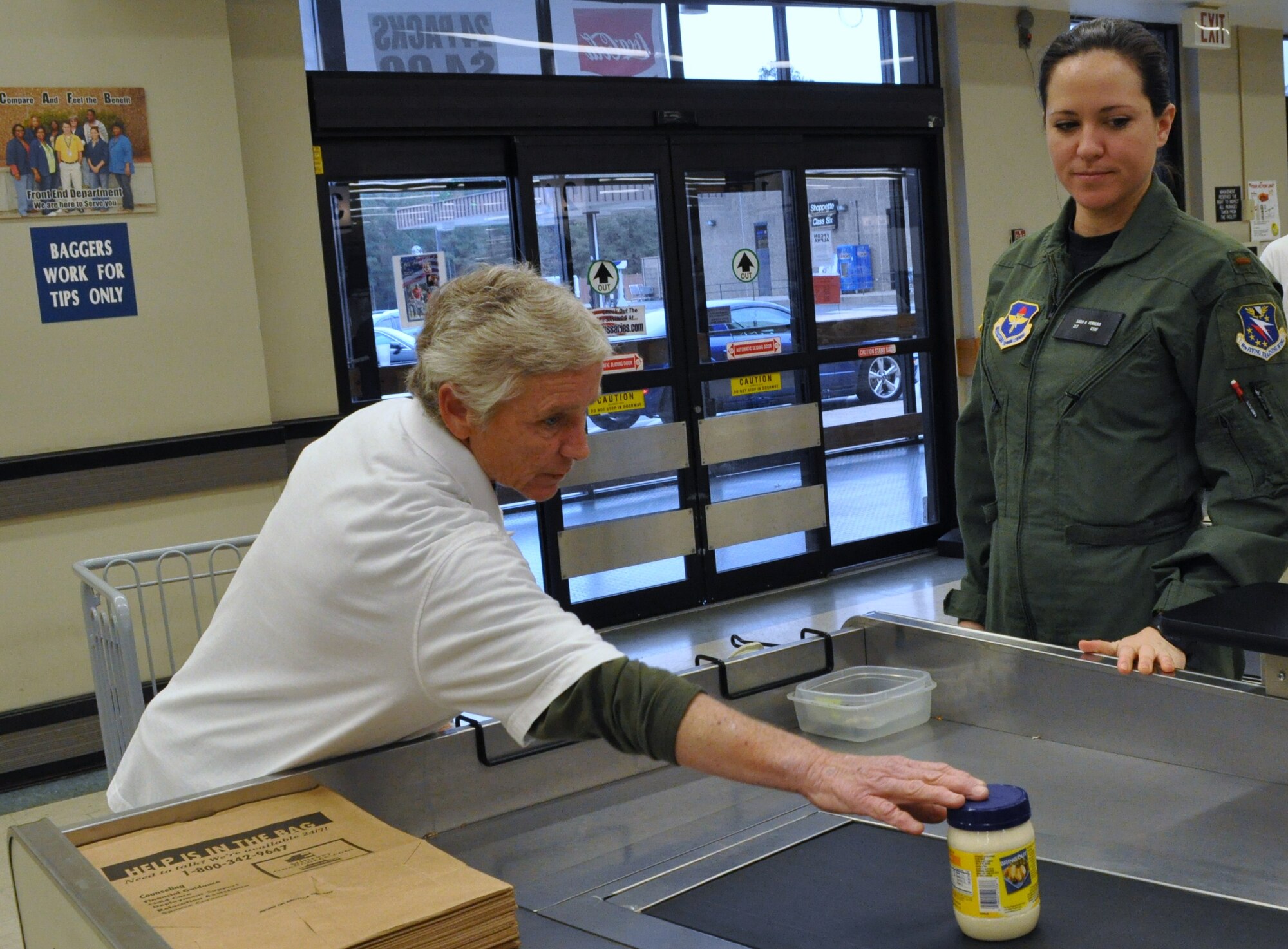 Head bagger Bea Desmidt loads groceries for Columbus Air Force Base commissary patron 2Lt Sara Ferrero, Specialized Undergraduate Pilot Training class 11-02, Nov. 17.  Desmidt has been sacking at the commissary since 1984.  (U.S. Air Force photo/Sonic Johnson)