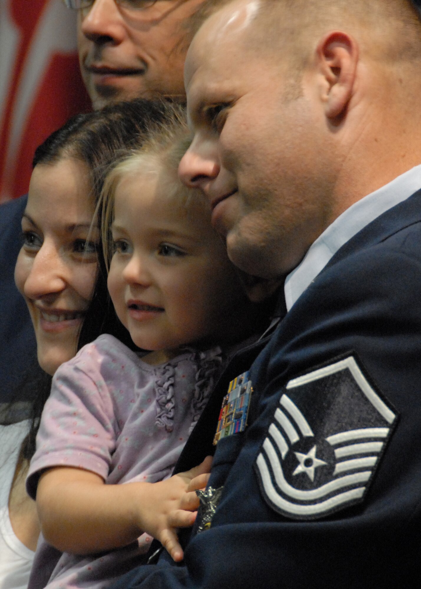 A new 919th Special Operations Wing senior NCO poses for a photo with his spouse and daughter during the NCO and senior NCO induction ceremony at Duke Field Nov. 7.  The ceremony was held to honor new staff sergeants and master sergeants within the wing.    (Air Force photo/Staff Sgt. Samuel King Jr.)