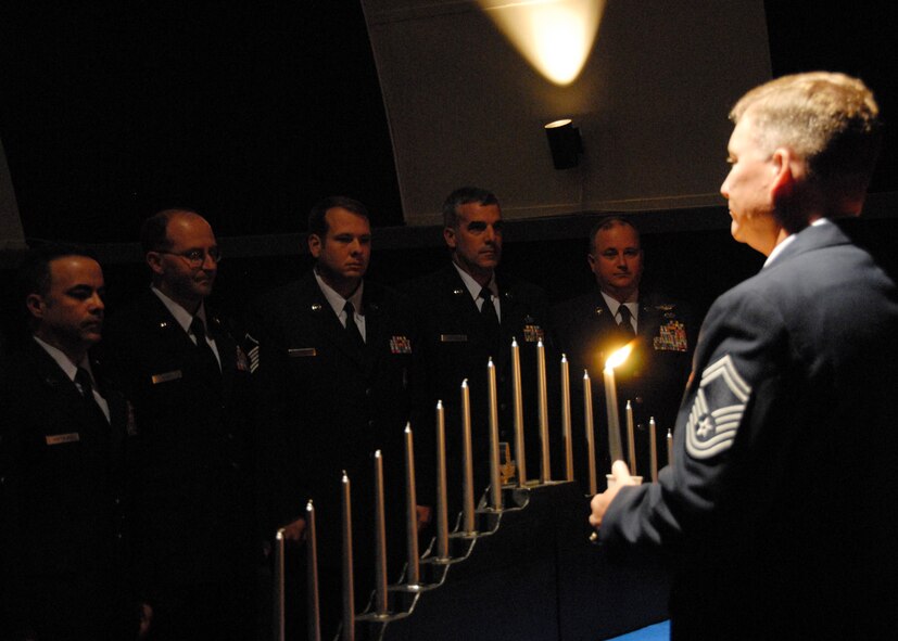 Senior Master Sgt. David Culver, 919th Medical Squadron, holds a candle in front of a group of 919th Special Operations Wing senior NCOs before the ceremonial candle lighting of each enlisted rank by the inductees at Duke Field Nov. 7.  The ceremony was held to honor new staff sergeants and master sergeants within the wing.    (Air Force photo/Staff Sgt. Samuel King Jr.)