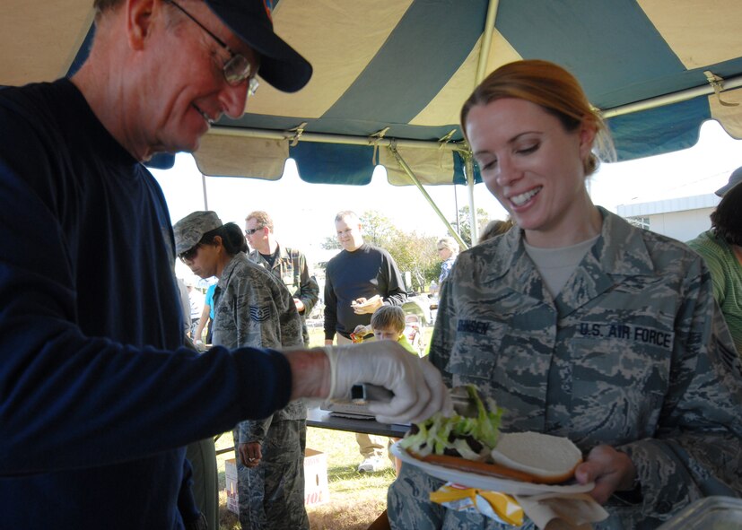 Fort Walton Beach Mayor Mike Anderson serves up some lettuce to Senior Airman Olivia Johnsen, 711th Special Operations Squadron, during Duke Field’s Family Day event Nov. 7.  The Family Day event brought reservists and their families together for food, games and music.  Local community leaders volunteered to help serve food, cook and set up tents for the annual event.  (Air Force photo/Staff Sgt. Samuel King Jr.)