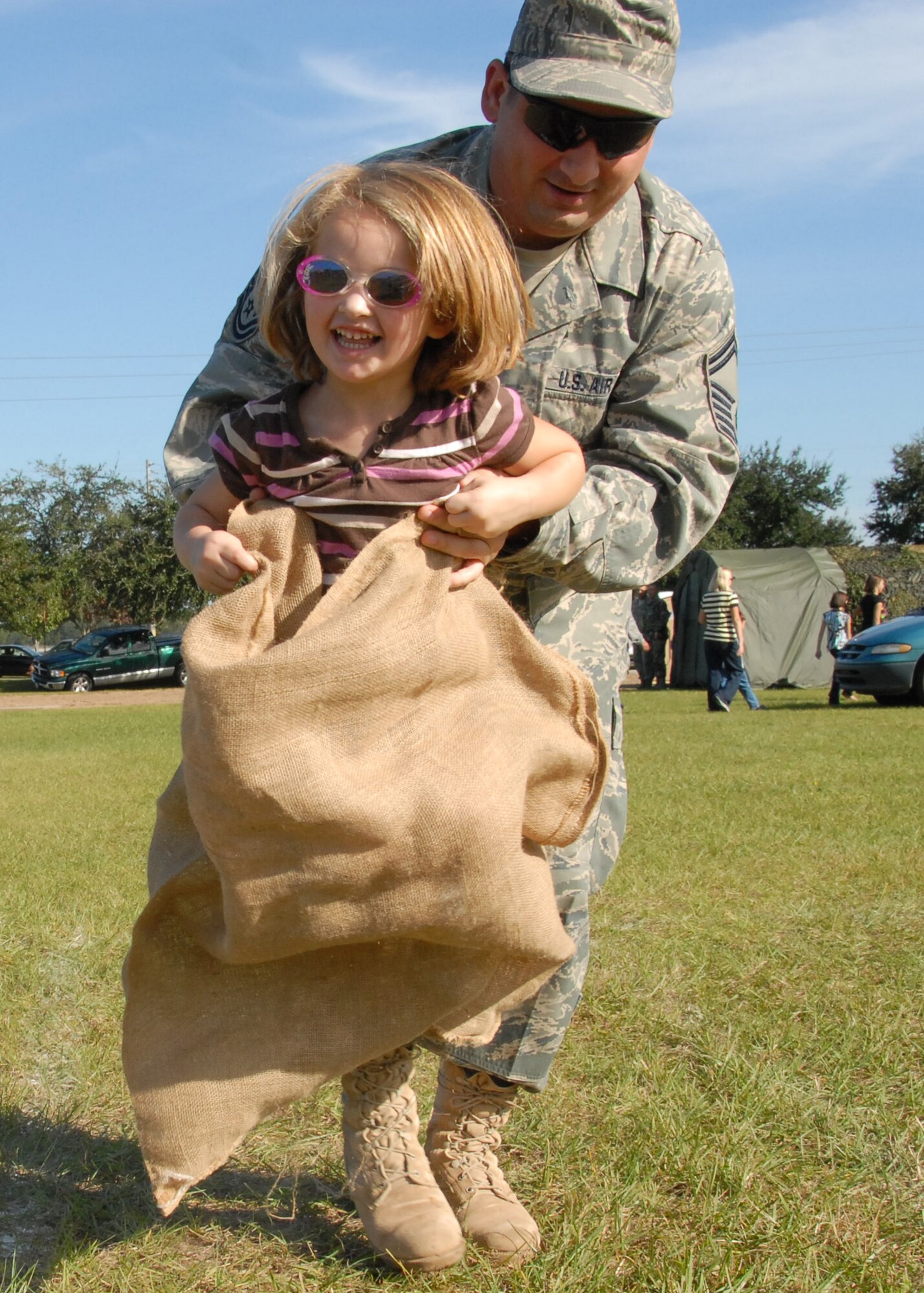 Senior Master Sgt. Anthony DeRosa, 919th Medical Squadron, “helps” his daughter in a sack race event during Duke Field’s Family Day event Nov. 7.  The Family Day event brought reservists and their families together for food, games and music.  (Air Force photo/Staff Sgt. Samuel King Jr.)