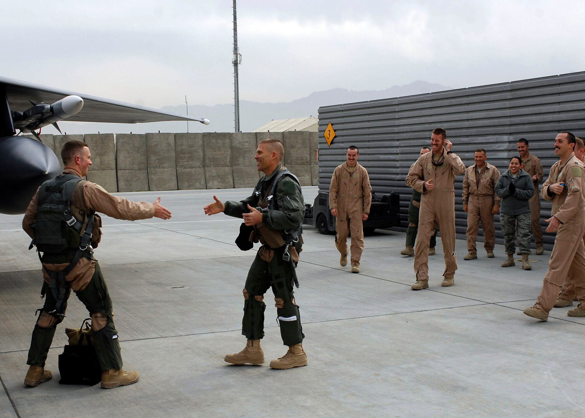 BAGRAM AIRFIELD, Afghanistan -- Brig. Gen. Steven Kwast (right) congratulates Capt. Ryan Bone (left) after their mission, Nov. 22, 2009.  Today marked a very important day for Capt. Bone, he reached the 1,000 flying hours.  "It feels good, reaching 1,000 hours in my first assignment," he said "not a lot of guys do that."  Capt. Bone is deployed from Seymour Johnson Air Force Base, N.C., and hails from Gainesville, Fla.  Gen. Kwast, the 455th Air Expeditionary Wing Commander, was previously stationed at Seymour Johnson AFB as the wing commander.  (U.S. Air Force photo/Senior Airman Felicia Juenke)