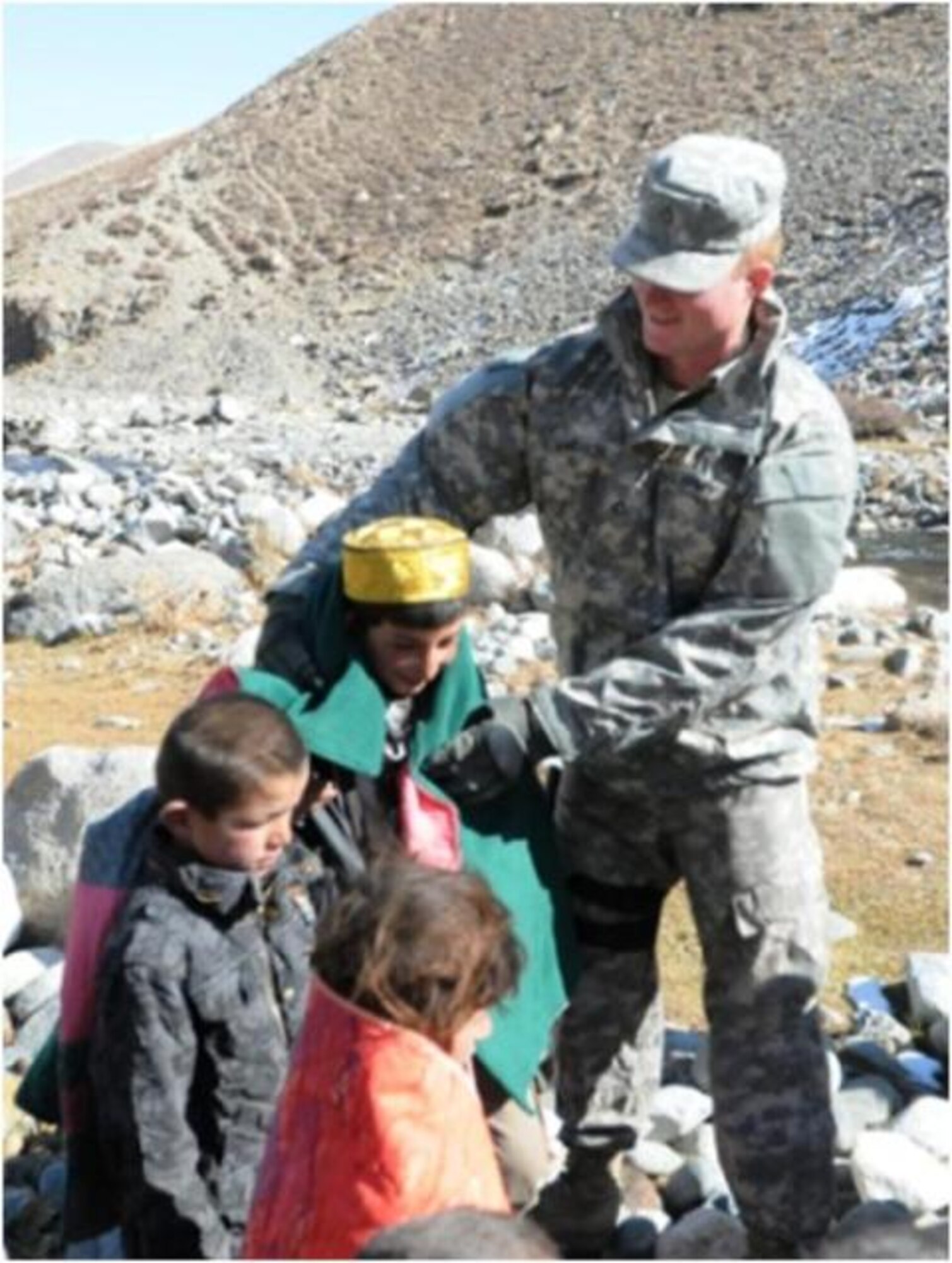 PANJSHIR PROVINCE, Afghanistan – Army Pvt. Orson Whitaker, Panjshir Provincial Reconstruction Team Civil Affairs, wraps a young resident from Dakhawak village, Paryan district, Panjshir province, Afghanistan, in a hand-made quilt during a material assistance drop to the area recently. The supplies are a part of the combined effort of the provincial government and the PRT to provide essential services and assistance to the citizens of the valley. (U.S. Air Force photo/Capt. John T. Stamm)