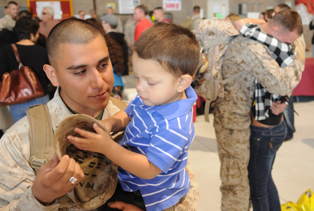 Lance Cpl. Ernest Carrillo, Marine Attack Squadron 214 ordnance technician, holds his son, Ernest Noel, for the first time in seven months after returning to the Marine Corps Air Station in Yuma, Ariz., Nov. 22, 2009, from a deployment to Afghanistan. Approximately 200 Marines from VMA-214 and Marine Aviation Logistics Squadron 13 arrived after spending half a year providing air support, armed reconnaissance and air defense for Marine Expeditionary Brigade-Afghanistan.
