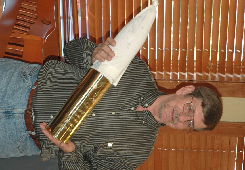Mr. Shaud admires his specially inscribed 105mm canon shell casing, a retirement memento presented to him by fellow Duke Field maintainers.  (U.S. Air Force photo/Staff Sgt. Jon McCallum)
