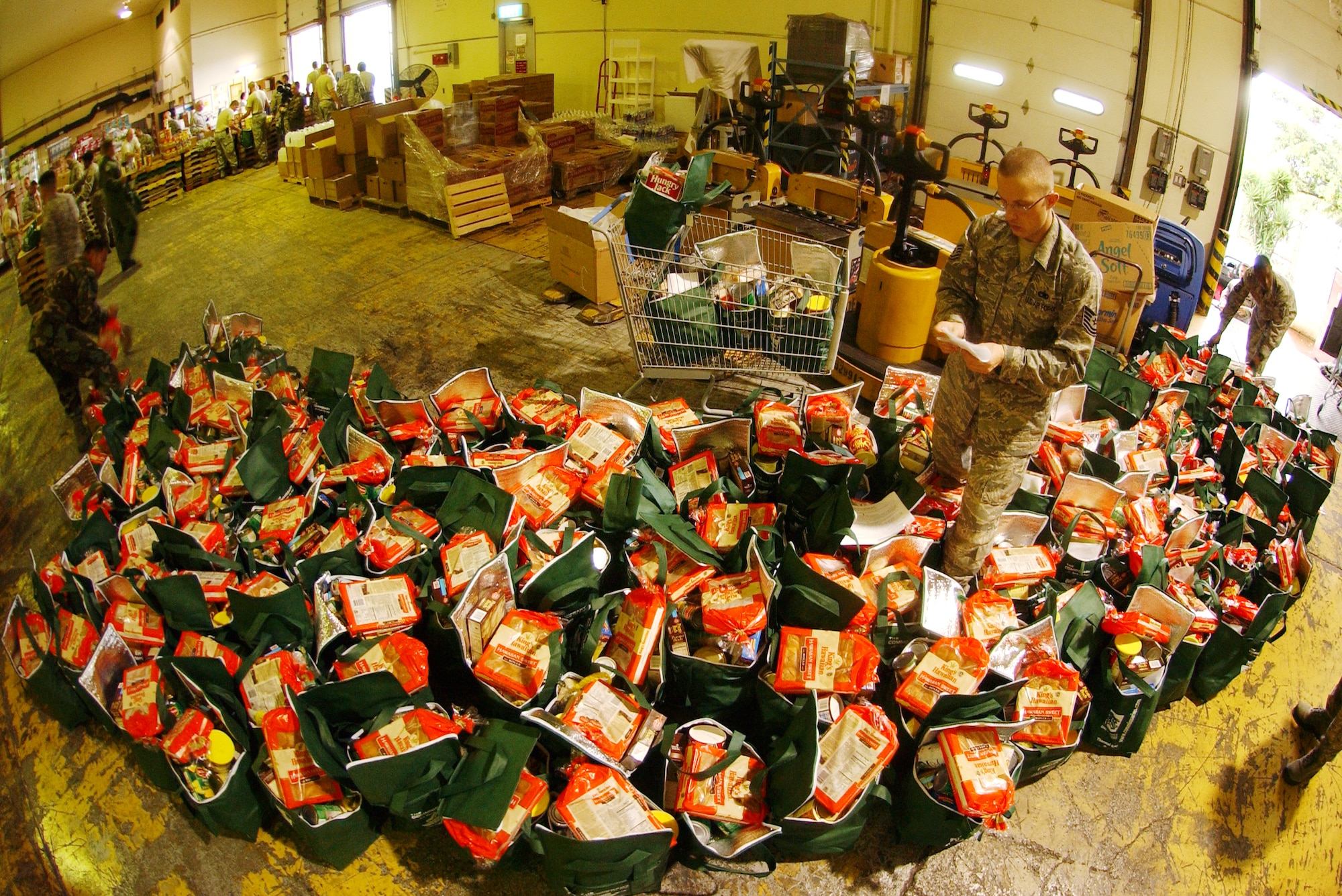 A military member places a list of the included items in each bag before loading the bags into a vehicle for delivery. Military members filled 275 bags with a Thanksgiving turkey and other canned goods for families in need at the Kadena Air Base Commissary as part of Operation Warmheart Nov. 24. Operation Warmheart is a charity designed to help enlisted personnel and their families with loans, grants, and other needs through fundraisers and donations. The 18th Wing Chapel donated more than $8K for this Thanksgiving food drive. 
(U.S. Air Force photo/Tech. Sgt. Rey Ramon) 



