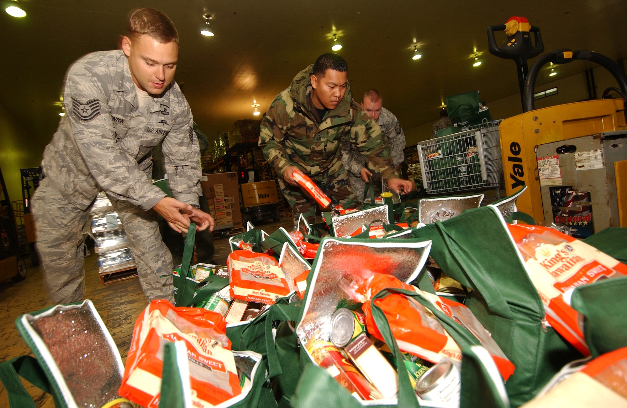 Military members prepare 275 bags filled with a Thanksgiving turkey and other canned goods for families in need at the Kadena Air Base Commissary as part of Operation Warmheart Nov. 24. Operation Warmheart is a charity designed to help enlisted personnel and their families with loans, grants, and other needs through fundraisers and donations. The 18th Wing Chapel donated more than $8K for this Thanksgiving food drive. (U.S. Air Force photo/Tech. Sgt. Rey Ramon) 

