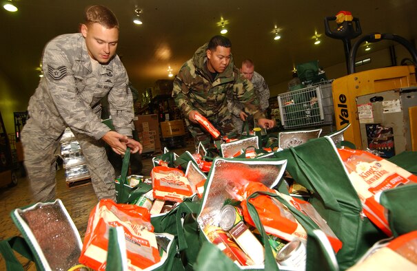 Military members prepare 275 bags filled with a Thanksgiving turkey and other canned goods for families in need at the Kadena Air Base Commissary as part of Operation Warmheart Nov. 24. Operation Warmheart is a charity designed to help enlisted personnel and their families with loans, grants, and other needs through fundraisers and donations. The 18th Wing Chapel donated more than $8K for this Thanksgiving food drive. (U.S. Air Force photo/Tech. Sgt. Rey Ramon) 

