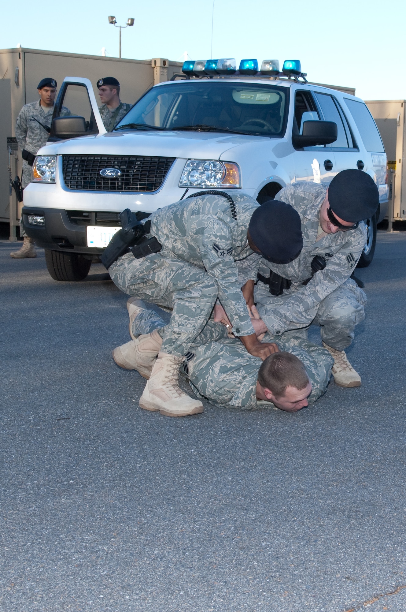 HANSCOM AIR FORCE BASE, Mass. - Airman 1st Class Ronald Ashley, 66th Security Forces Squadron installation patrolman, and Airman 1st Class John Domenicis, 66 SFS senior patrolman, physically arrest and handcuff Senior Airman John Reed, 66 SFS standards and evaluation, and playing the role of the perpetrator, after a simulated pursuit exercise. A photographer from 66th Air Base Wing Public Affairs documented security forces training and patrols the evening of Nov. 20 and the early morning of Nov. 21. (U.S. Air Force Photo by Rick Berry)