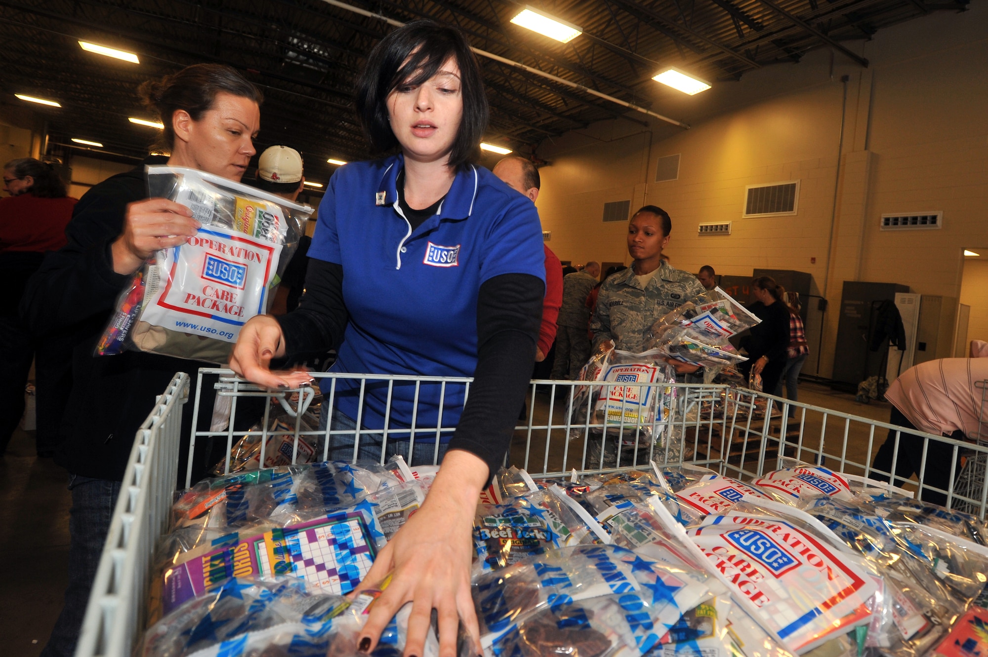HANSCOM AIR FORCE BASE, Mass. - A representative from the United Service Organizations counts portions of care packages to be packed into boxes then shipped to U.S. troops deployed around the globe. Two shifts of 200 volunteers including military, family members, Boston Celtics Dancers, USO representatives and many others packed 10,000 boxes of snacks, toiletries, books and other supplies here at Hanscom Nov. 21. (U.S. Air Force Photo by Mark Herlihy)
