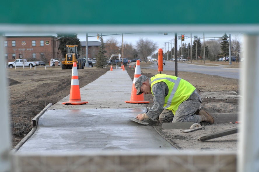 MINOT AIR FORCE BASE, N.D. -- Staff Sgt. Robert Owens, 5th Civil Engineer Squadron pavements and equipments craftsmen, installs new sidewalks in front of the base shoppette along Missile Ave. here Nov. 23. The new sidewalks provide for greater access to base facilities year round. (U.S. Air Force photo by Airman 1st Class Aaron-Forrest Wainwright)