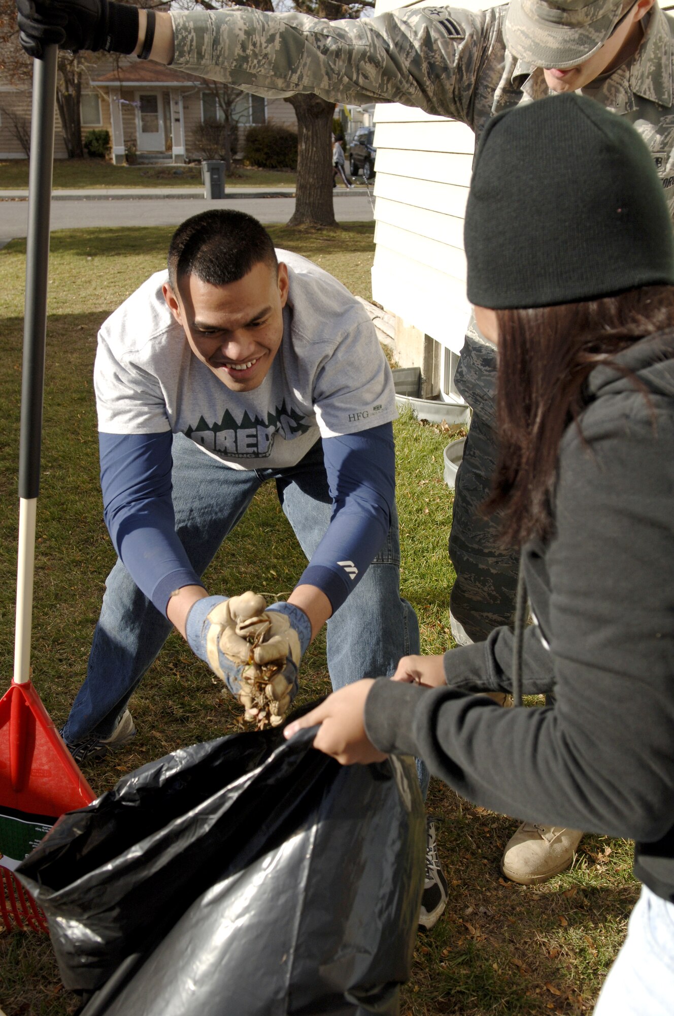 FAIRCHILD AIR FORCE BASE, Wash. – Airman 1st Class Talamon Risenn, 92nd Aircraft Maintenance Squadron, scoops up a handful of leaves from the yard of a deployed Airman’s home into a trash bag with the help of fellow volunteering Airmen here Nov. 7. (U.S. Air Force Photo/ Airman 1st Class Natasha E. Stannard)