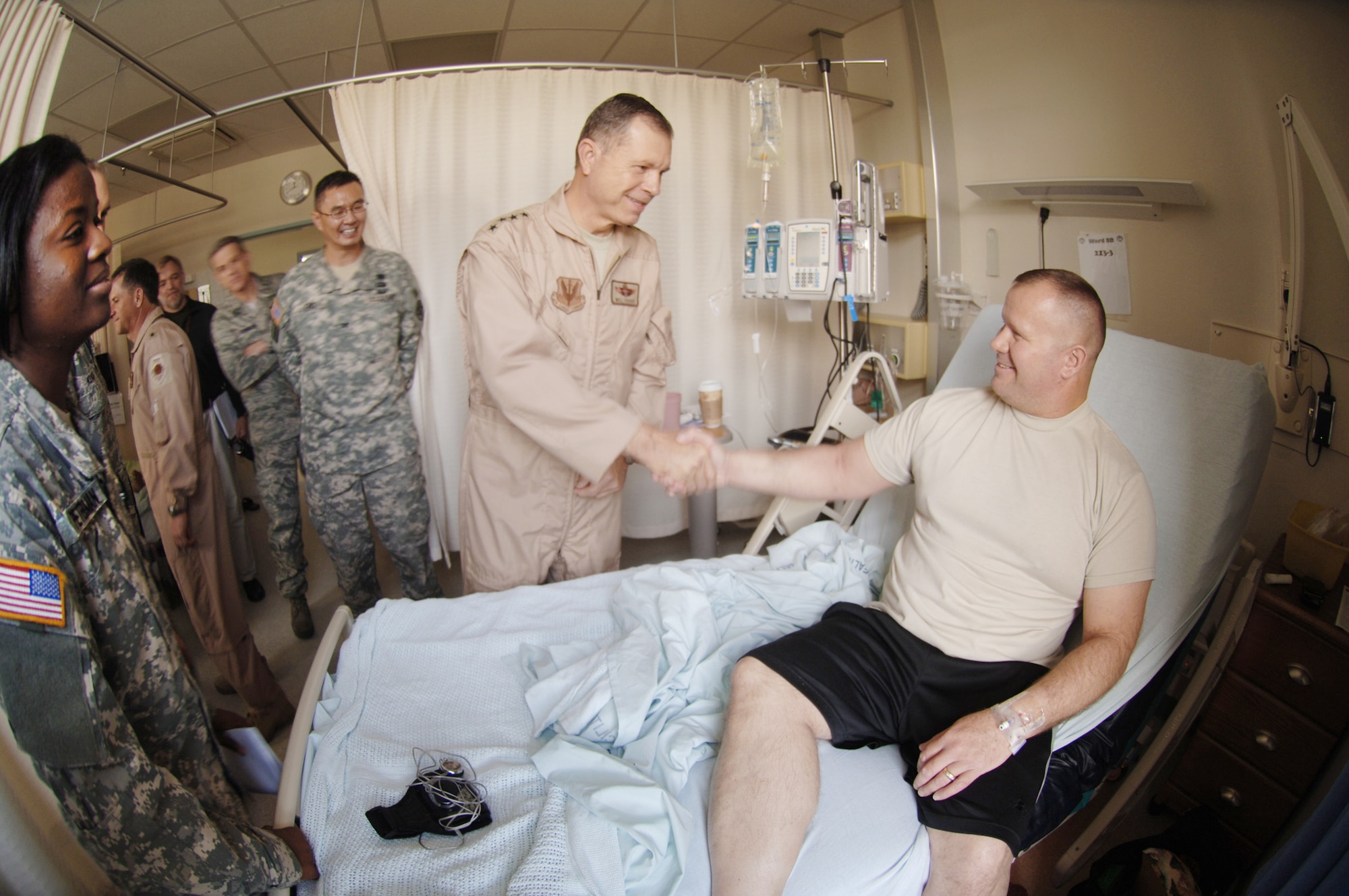 Gen. William M. Fraser III meets with Army Staff Sgt. Brian Bunch at Landstuhl Regional Medical Center, Germany, Nov. 20, 2009. Sergeant Bunch received treatment for injuries sustained in Afghanistan and was about to be discharged to return to his home station of Fort Polk, La. Army Col. John Cho (third from right), and Army Capt. Ebony Peterman (left) helped guide the hospital tour. Since 2004, the hospital has treated more than 58,000 wounded U.S. and coalition servicemembers and civilians injured in Iraq and Afghanistan. General Fraser is the commander of Air Combat Command and Sergeant Bunch is from the 546th Maintenance Battalion. Colonel Cho is the commander of the Landstuhl Regional Medical Center Hospital and Captain Peterman is a charge nurse. (Defense Department photo/Master Sgt. Scott Wagers/Defense Media Activity Ramstein) 