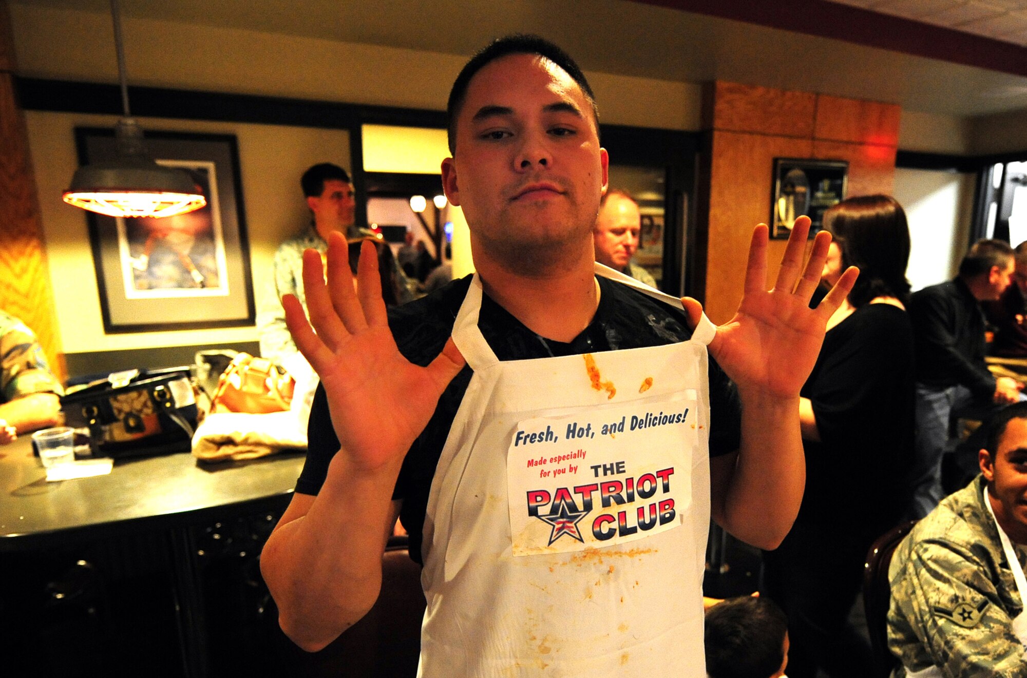 OFFUTT AIR FORCE BASE, Neb. - Senior Airman Michael Makela, 55th Force Support Squadron, shows off his stained apron ladened with remnants of four dishes from the Fear Factor competition held at the Patriot Club Nov. 20.  Participants, with precautionary buckets nearby, downed four stomach-turning dishes for the chance to win cash prizes.

U.S. Air Force photo by Josh Plueger

