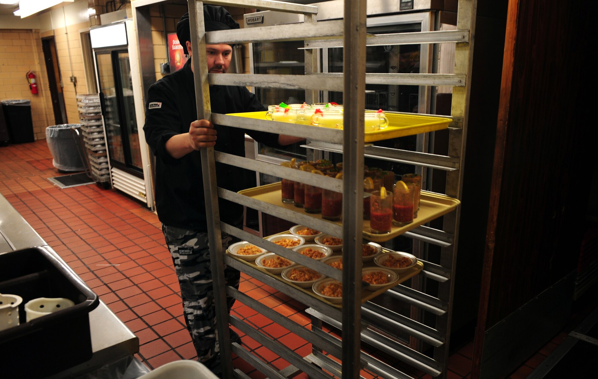 OFFUTT AIR FORCE BASE, Neb. - Patriot Club Head Chef Javier Ruiz rolls the Fear Factor dishes out of the club's kitchen as he makes his way to the competitors waiting to sample his concoctions Nov. 20.  Participants, with precautionary buckets nearby, downed four stomach-turning dishes for the chance to win cash prizes.

U.S. Air Force photo by Josh Plueger
