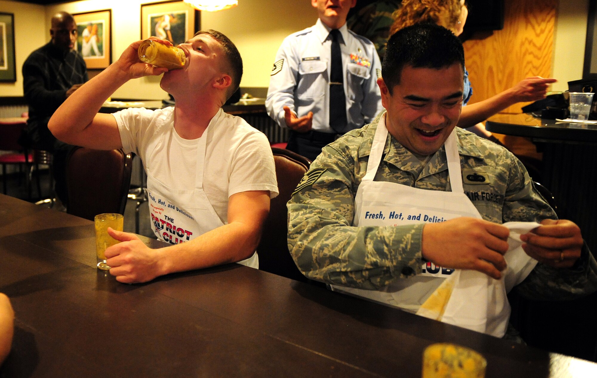 OFFUTT AIR FORCE BASE, Neb. - U.S. Navy Seaman Joseph Smith, Strategic Communications Wing One Detachment, takes an encore glass of the V-13 juice after finishing second in the Patriot Club's Fear Factor competition Nov. 20 while fellow competitor Tech. Sgt. Nolan Liwanag, U.S. Strategic Command, cleans up. Participants, with precautionary buckets nearby, downed four stomach-turning dishes for the chance to win cash prizes.

U.S. Air Force photo by Josh Plueger
