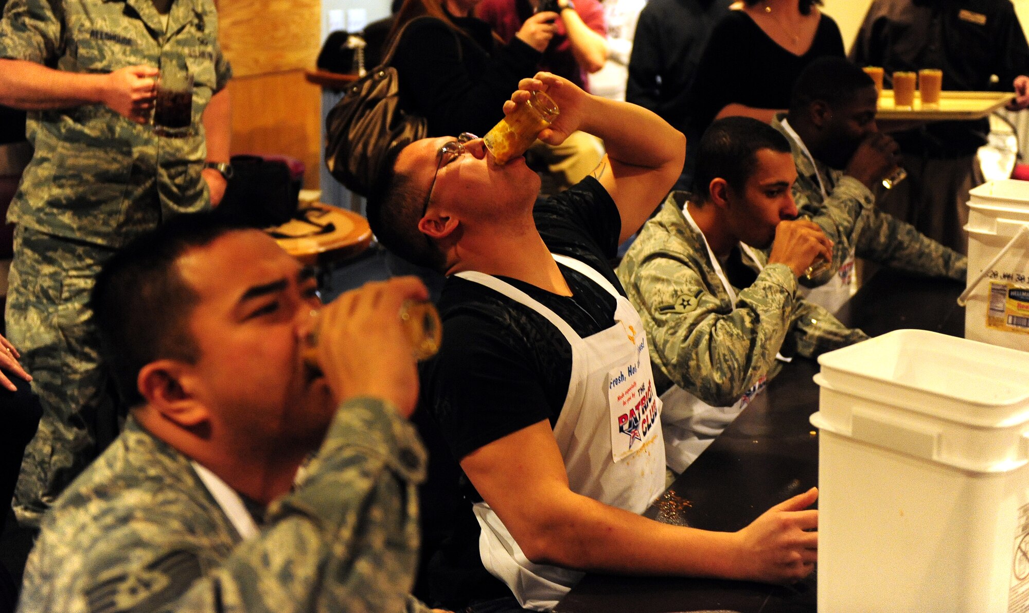 OFFUTT AIR FORCE BASE, Neb. - (Center) Senior Airman Michael Makela, 55th Force Support Squadron, downs a full glass of what the Patriot Club kitchen staff would only call V-13 Juice during a Fear Factor competition held at the club Nov. 20.  Participants, with precautionary buckets nearby, downed four stomach-turning dishes for the chance to win cash prizes.

U.S. Air Force photo by Josh Plueger
