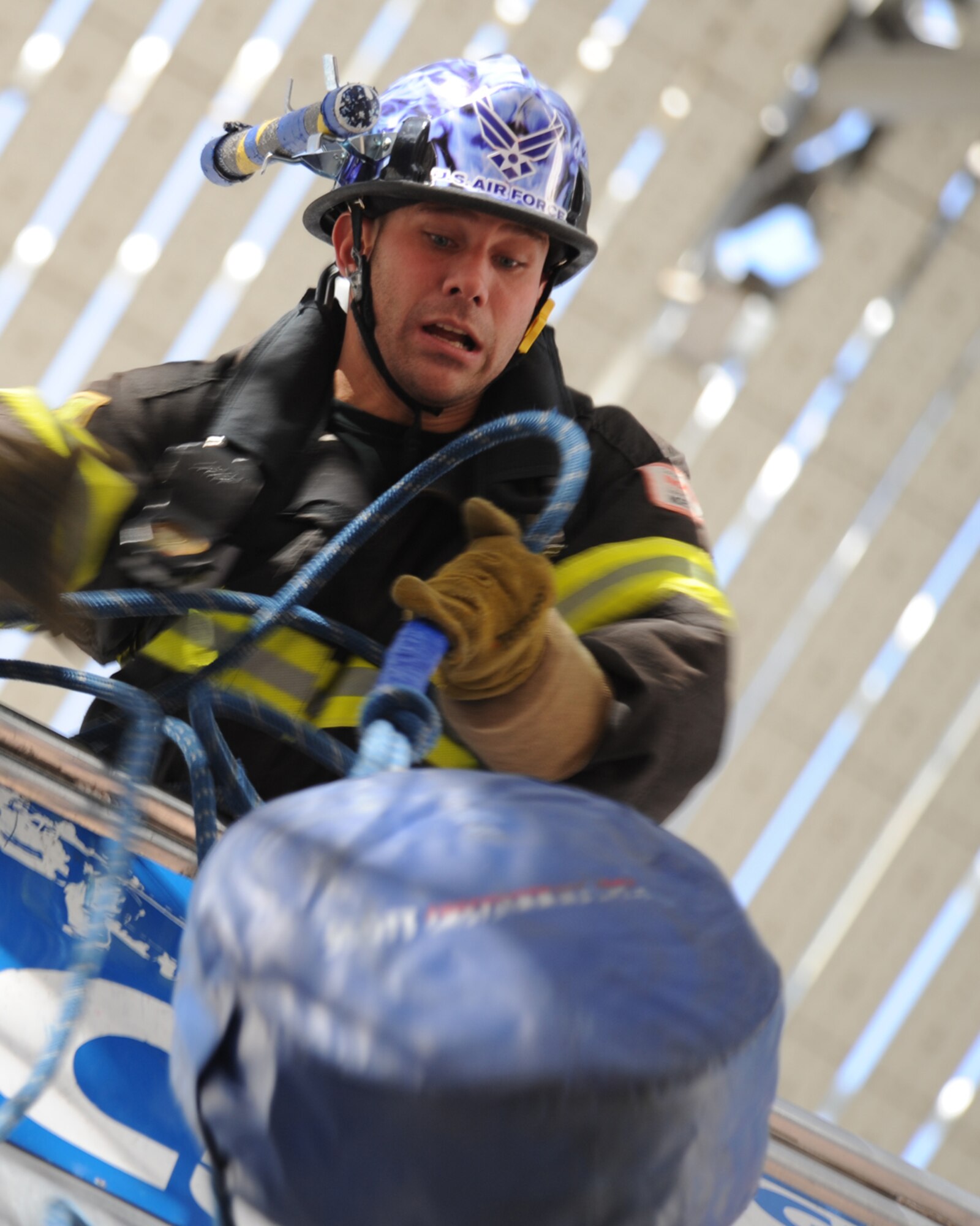 LAS VEGAS - Tech. Sgt. Cory McGee, 509th Civil Engineer Squadron, Combat Challenge Team lead from Whiteman Air Force Base, Mo., hoists a 45-pound hose up the five-story tower, in the coed tandem team course run during the Firefighter Combat Challenge, Nov. 20. Sergeant McGee and Senior Airman Meghan Melanson, 509 Civil Engineer Squadron, placed fourth in the world among Air Force teams during the competition.  (U.S. Air Force photo by Airman First Class Carlin Leslie)