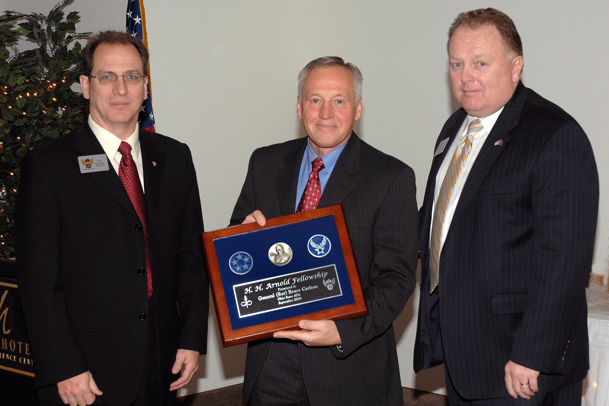 Retired Gen. Bruce Carlson, former Air Force Materiel Command commander,
accepts the Air Force Association's H.H. Arnold Fellowship Award from (left)
Jeff Liffick, AFA Wright Memorial Chapter #212 president, and (right) John
McCance, AFA Great Lakes region president, during a Nov. 20 recognition
breakfast at the Hope Hotel and Conference Center. General Carlson was
presented with the award for his encouragement and support of this year's
U.S. Air, Trade and Technology Expo. (Photo by Bill Pugh)