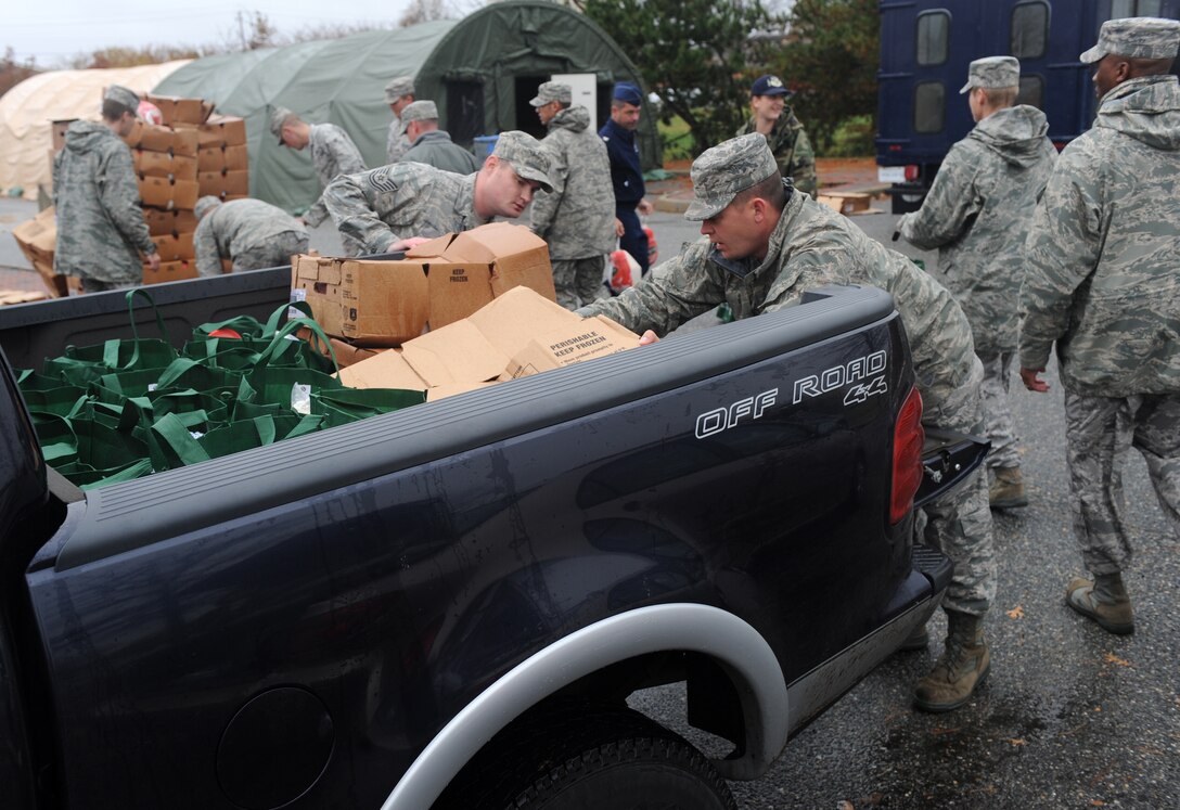 LANGLEY AIR FORCE BASE, Va. - After filling bags with Thanksgiving food during Operation Warmheart Nov. 23, Langley personnel load the bags onto a truck for distribution.  Operation Warmheart is a First Sergeants' Association community outreach program designed to support Airmen and their families during the holiday season. (U.S. Air Force photo/Senior Airman Zachary Wolf)