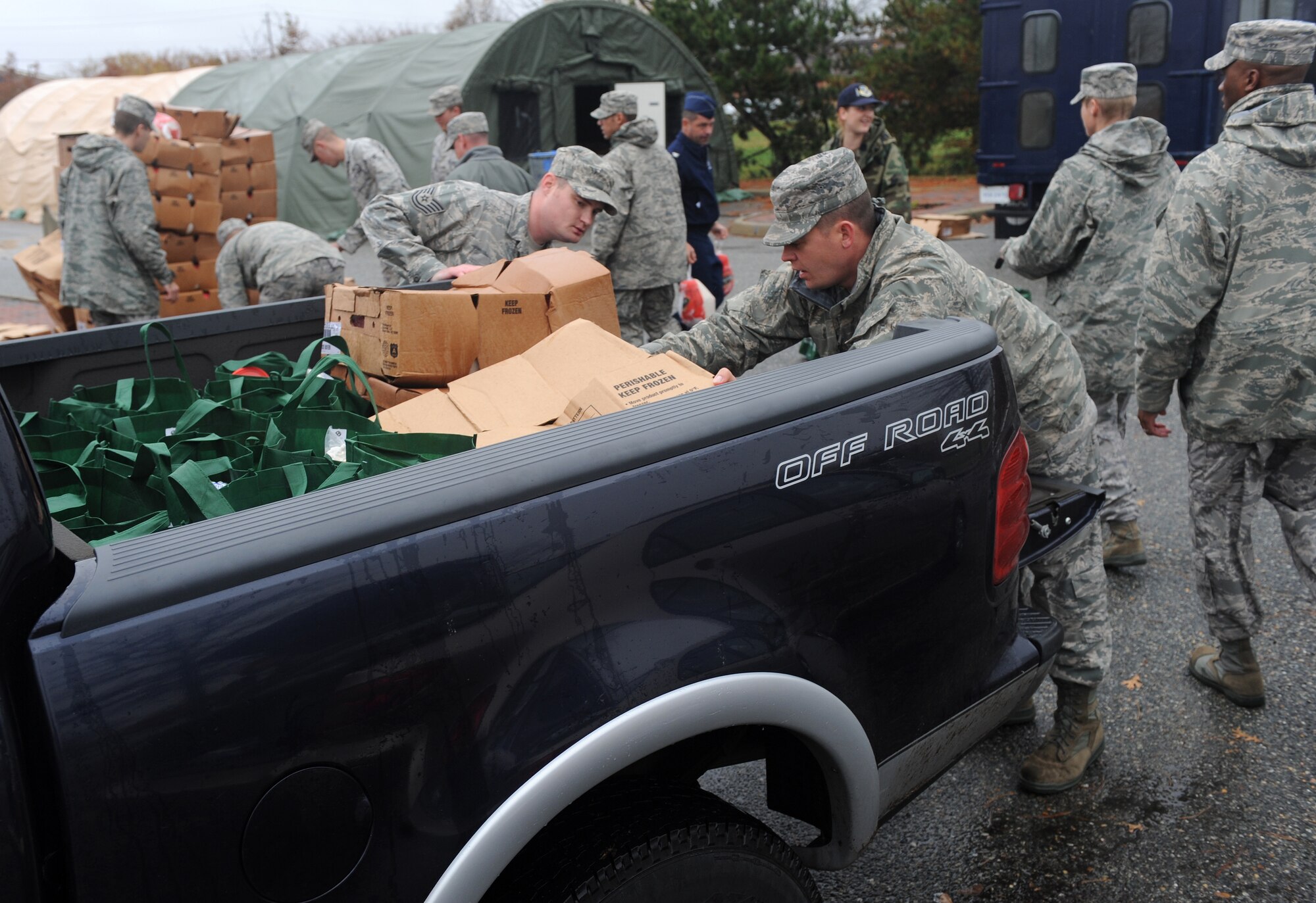 LANGLEY AIR FORCE BASE, Va. - After filling bags with Thanksgiving food during Operation Warmheart Nov. 23, Langley personnel load the bags onto a truck for distribution.  Operation Warmheart is a First Sergeants' Association community outreach program designed to support Airmen and their families during the holiday season. (U.S. Air Force photo/Senior Airman Zachary Wolf)