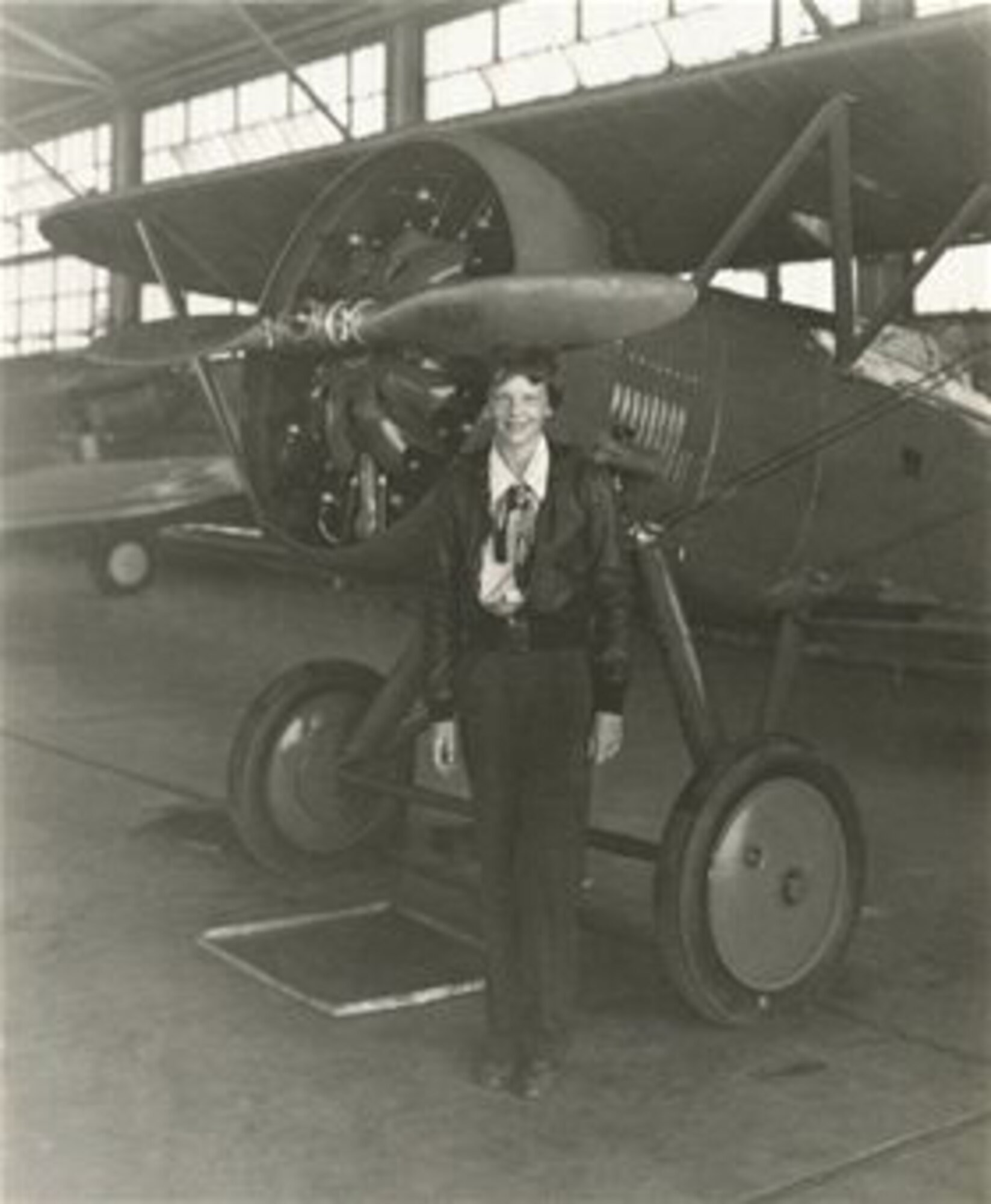 Amelia Earhart stands in front of a Boeing P-12 in a hangar at March Field, Calif., in 1935. The P-12 was flown by the 17th Pursuit Group at March Field from 1931 to 1932, before being replaced by the Boeing P-26 "Peashooter," the Air Corps' first all-metal mono-wing fighter. (March Field Historical photo)
