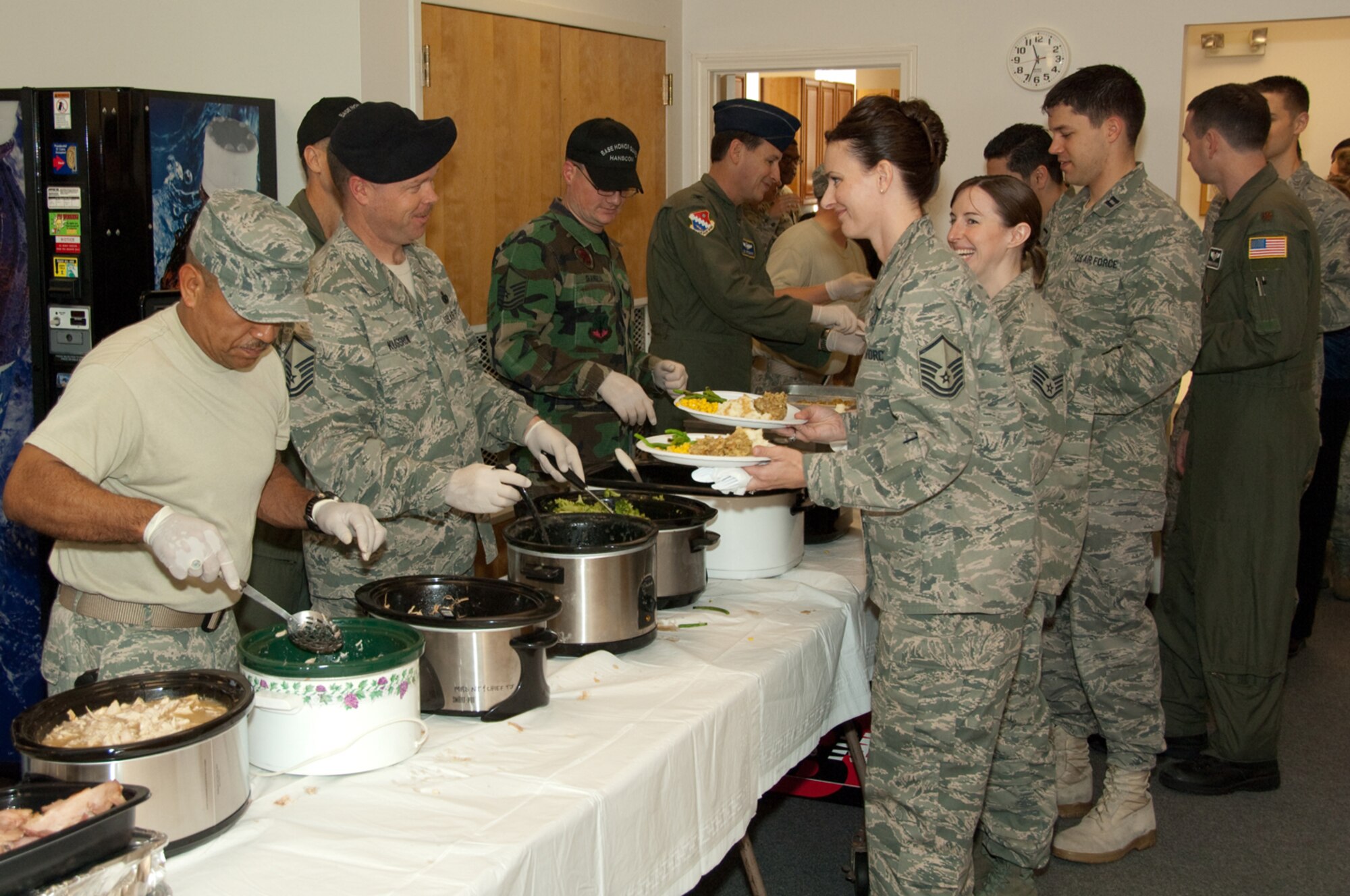 HANSCOM AIR FORCE BASE, Mass. -- Leadership from the 66th Air Base Wing serve turkey, ham and side dishes to wing personnel during a Wingman Day potluck luncheon, held at the Hanscom Conference Center Nov. 20. Wingman Day activities were held base-wide to celebrate camaraderie and encourage team building among Hanscom personnel.  (U.S. Air Force photo by Rick Berry)  