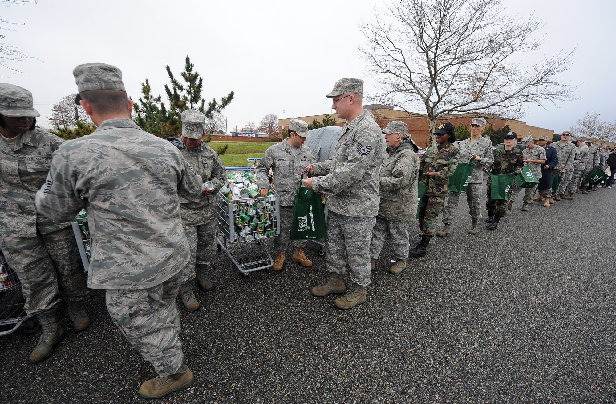 LANGLEY AIR FORCE BASE, Va. – Eighty Langley personnel form an assembly line to pack bags with Thanksgiving favorites during Operation Warmheart Nov. 23. Operation Warmheart is a First Sergeants' Association community outreach program designed to support Airmen and their families during the holiday season. (U.S. Air Force photo/Airman Rebecca Montez)