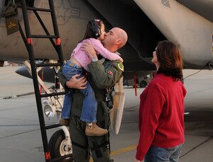 LANGLEY AIR FORCE BASE, Va. -- Maj. John Pope, 71st Fighter Squadron flight physician, greets his daughter Maryn, 5, and wife Alainna upon arrival Nov. 21 following weapons school support at Nellis Air Force Base, Nev. Major Pope and his team contributed weapons systems and adversary role support to pilots training there. (U.S. Air Force photo/Airman Rebecca Montez)