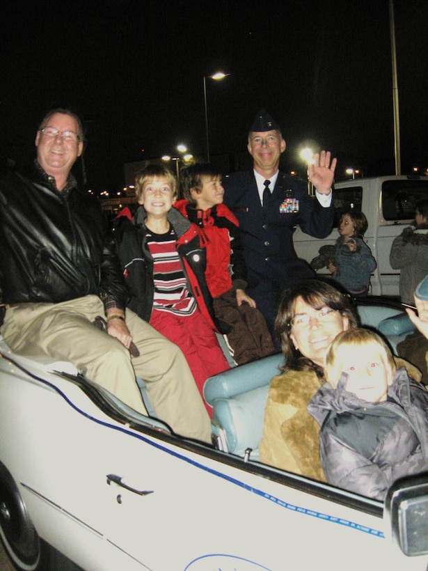 Wichita Falls Mayor Lanham Lyne (left) Col. Michael Hake(right), 82nd Training Wing vice commander, his three sons and wife, Chris(lower left), share the Grand Marshall Cadillac Nov. 21 in the city’s City Lights parade. Sheppard's Color Guard, along with the Drum and Bugle Corps, led the parade. (U.S. Air Force photo/Debi Smith)

