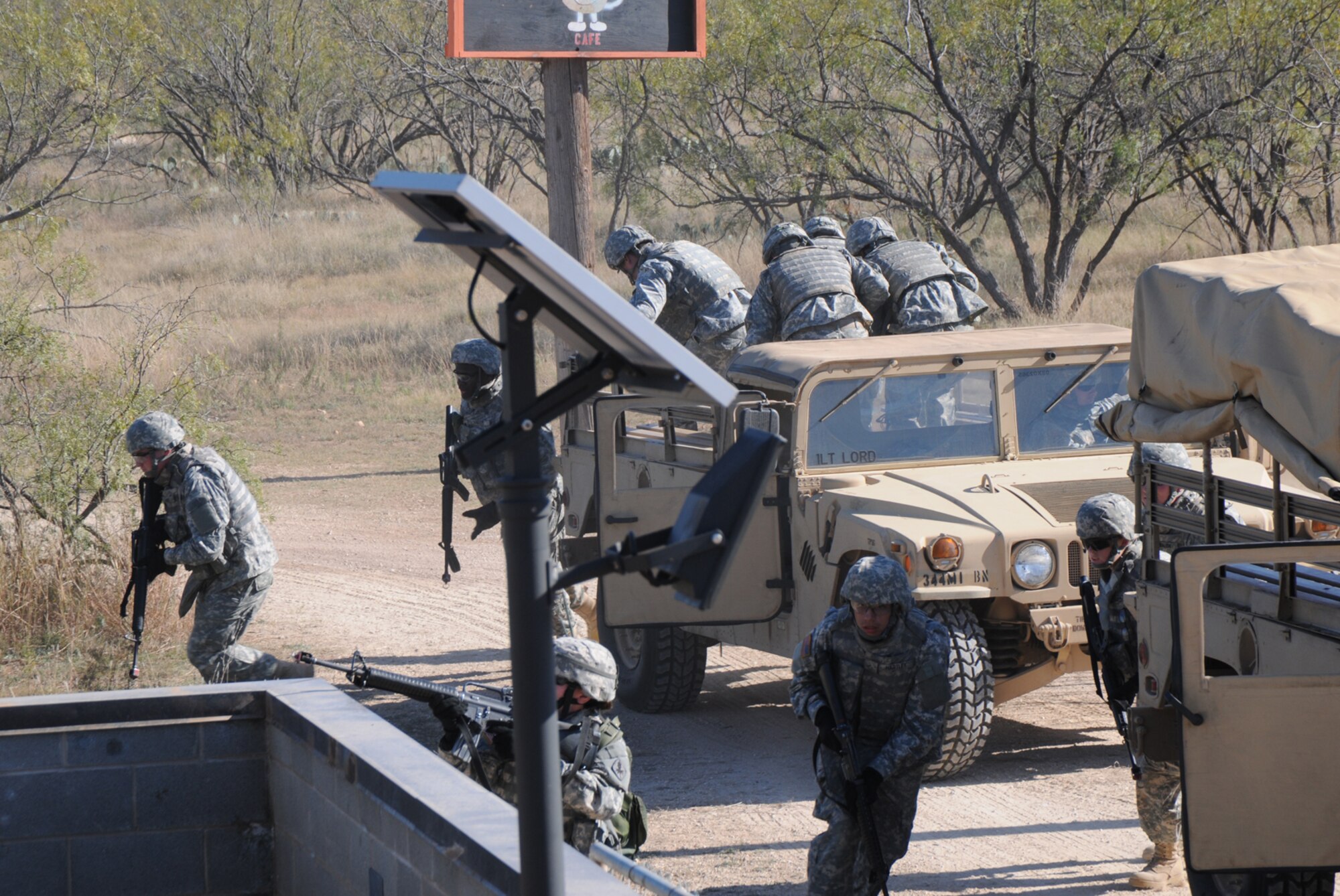 GOODFELLOW AIR FORCE BASE, Texas -- Soldiers from the 344th Military Intelligence Battalion Alpha Company exit their vehicles during an ambush in a simulated small Iraqi village during Community Appreciation Day, Nov. 21, 2009. Other events during the day included military working dog demonstrations, firefighting exercises, a Marine Corps Martial Arts Program demonstration, and a bus tour of the base. (U.S. Air Force photo/Airman Clayton Lenhardt)
