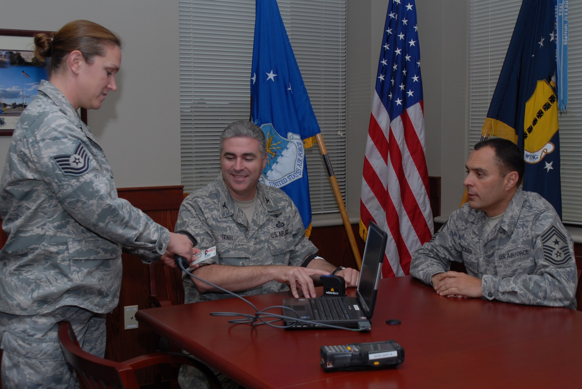 GOODFELLOW AIR FORCE BASE, Texas -- Col. Thomas Geary, 17th Training Wing commander, and Tech. Sgt. Rachel Taylor, 17th Security Forces Squadron, demonstrates the registration process for the Defense Biometric Identification System to Chief Master Sgt. Frederick Ricker, 17th Training Wing command chief master sgt., Nov. 20, 2009. DBIDS is a Department of Defense identity authentication tool. (U.S. Air Force photo/Staff Sgt. Laura R. McFarlane)
