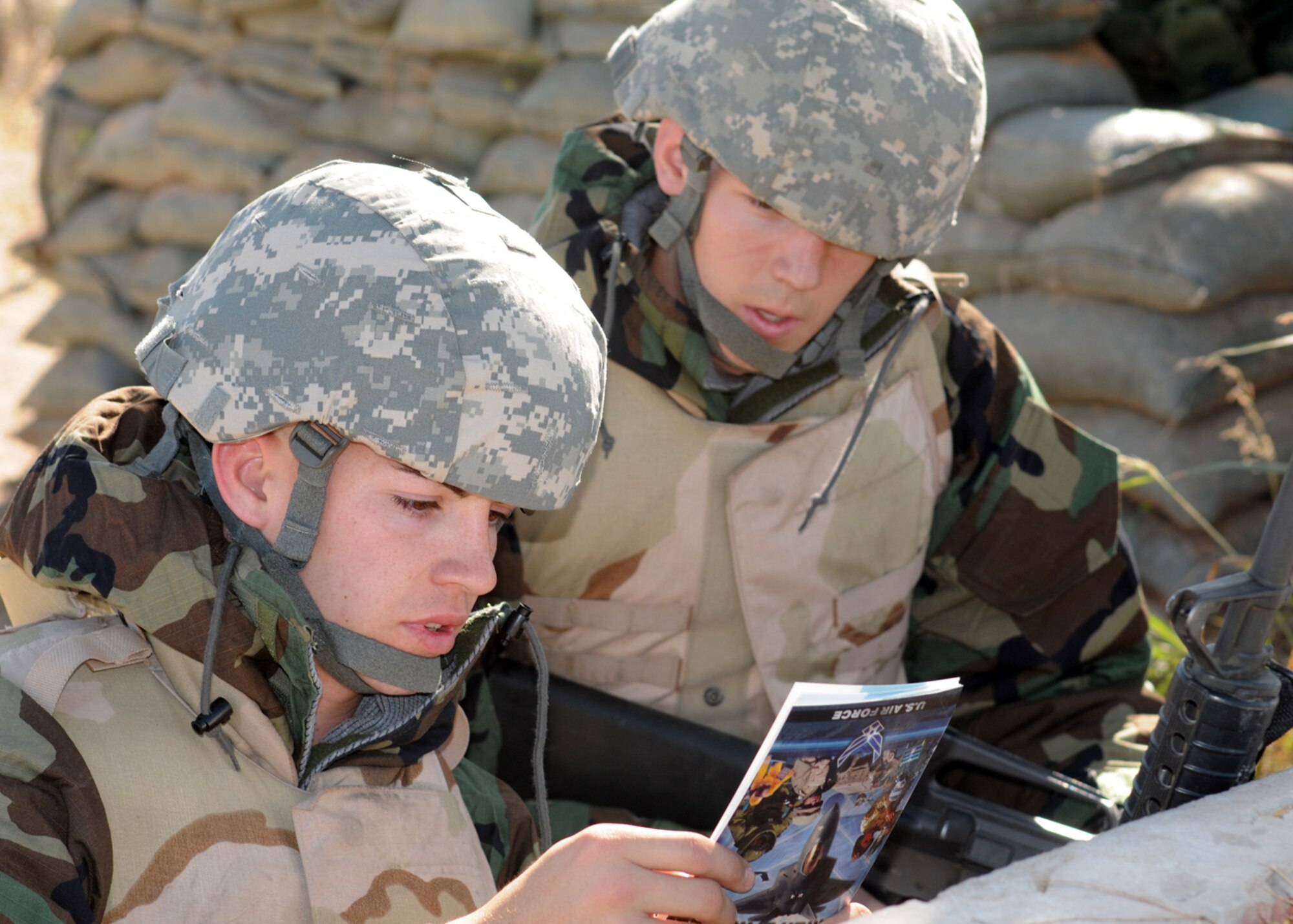 GOODFELLOW AIR FORCE BASE, Texas -- Senior Airman Jeffery Hart, 17th Training Group, and Airman 1st Class Benjamin Braker, 17th Communications Squadron, review the Airman's Manual during a field training exercise at Forward Operating Base Sentinel, Nov. 19, 2009. FOB Sentinel is used to simulate real world conditions and scenarios at Goodfellow. (U.S.  Air Force photo/Airman Clayton Lenhardt)
