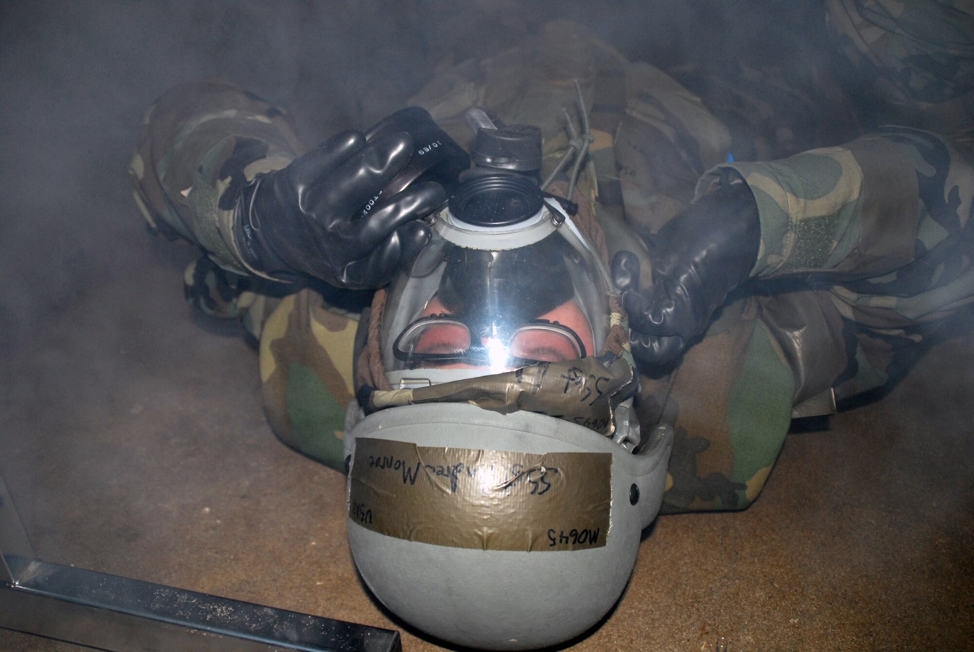 Staff Sgt. Andrew Monroe, 19th Contracting Squadron contract specialist, dons his gas mask and checks for a seal after his bunker was hit with a simulated missile attack during a base exercise Nov. 17. (U.S. Air Force photo by Senior Airman Michael Watkins)