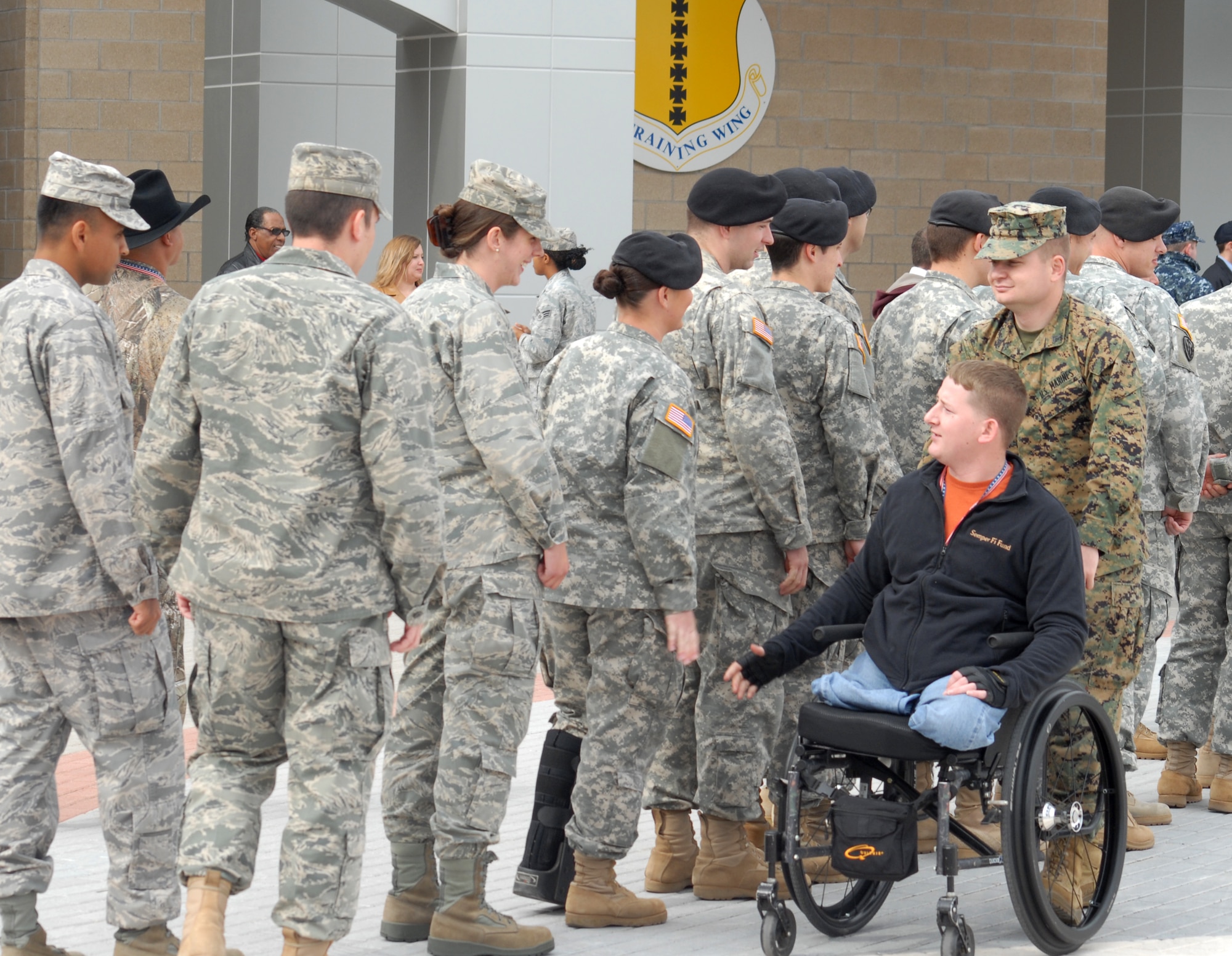 Marine Corporal Jonathan Rist, escorted by Corporal Pereta, moves through a crowd of Soldiers, Sailors, Airmen and Marines, shaking hands during a visit to Goodfellow AFB, Texas on Nov. 20.  Corporal Rist is a wounded veteran taking part in the annual Hunt for Heroes event in West Texas hosted by the Show of Support Military Hunt Inc., a nonprofit organization.  The criteria for the hunt are the veteran must have been wounded or disfigured and discharged from the military. (U.S. Air Force photo/Robert D. Martinez)