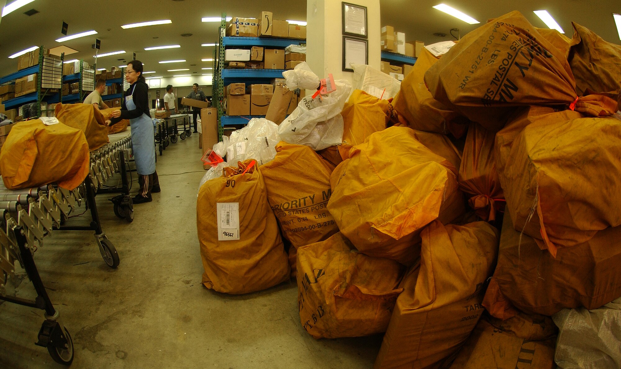 Akari Yamashiro, a post office holiday hire, processes mail as it is offloaded from a mail truck Nov. 23. During most of the year, postal workers here process roughly 150 packages daily, but during the next month over the holidays, postal workers typically process more than 500 packages daily. Beginning Nov. 30, the postal service center staff will need more volunteers to help with holiday season mail surge through Dec. 24. Call 634-4240 for more information on volunteer requirements. (U.S. Air Force photo/Staff Sgt. Jason Lake)  